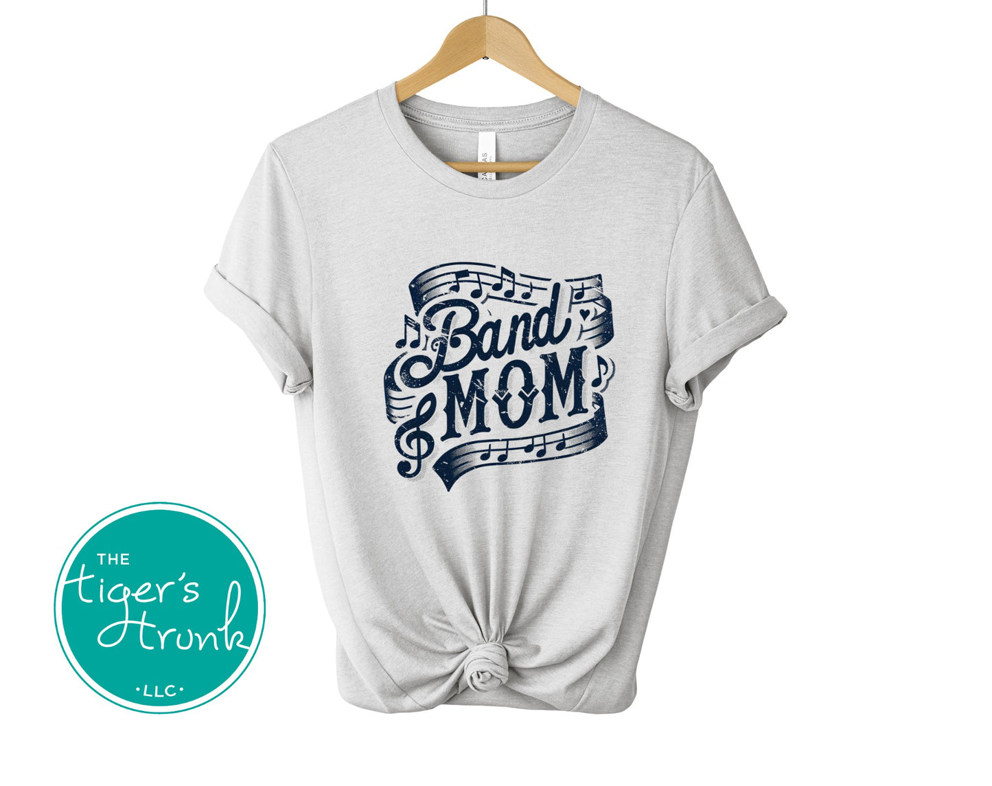 White t-shirt with 'Band Mom' design on a hanger, branded with 'The Tiger's Trunk'.