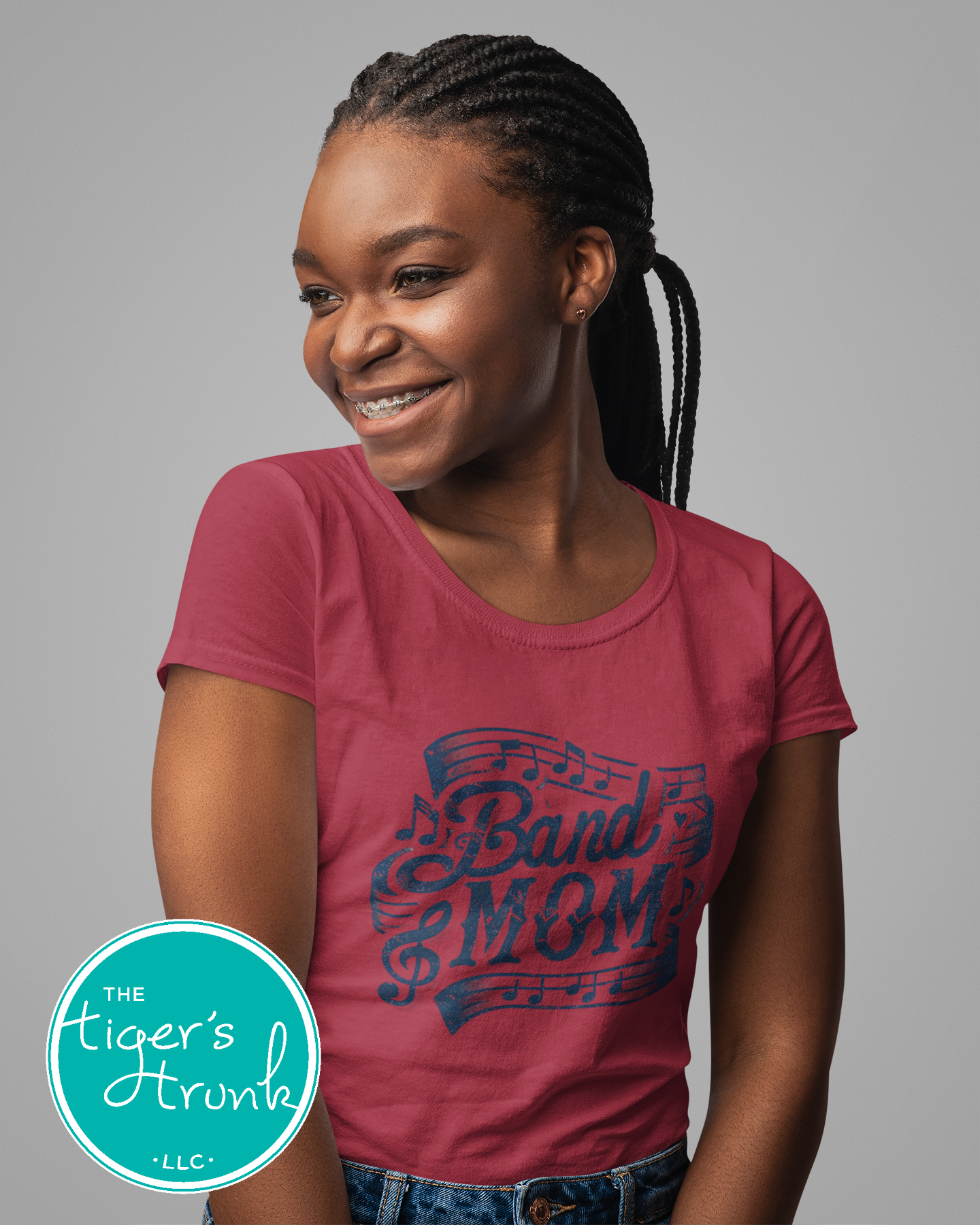 Young girl wearing a red 'Band Mom' t-shirt with a gray background
