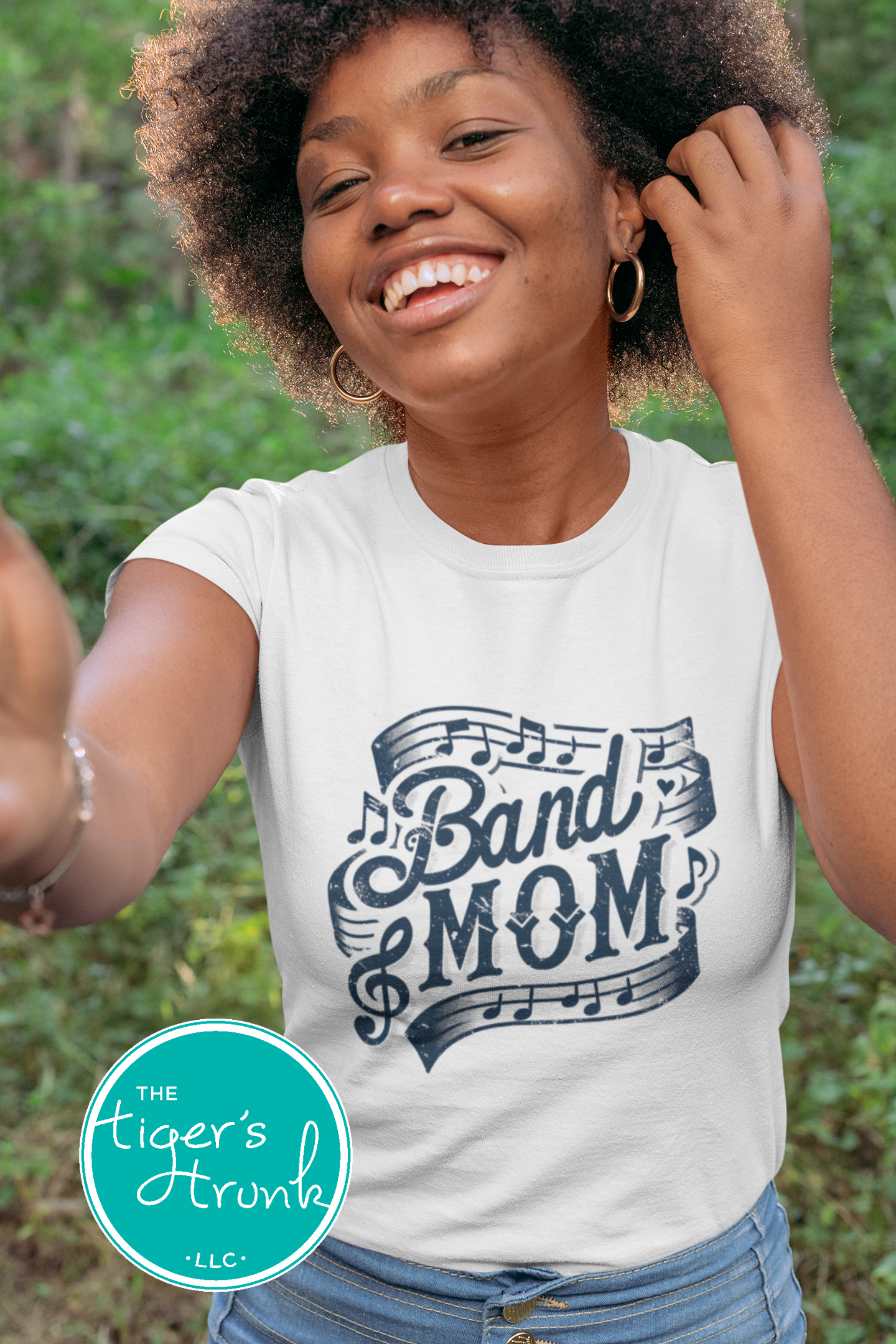 Woman wearing a 'Band Mom' t-shirt with a green logo in the corner.
