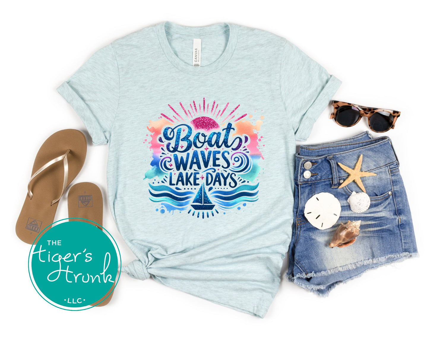 Light blue t-shirt with 'Boat Waves Lake Days' design, paired with denim shorts, sandals, sunglasses, and a starfish on a white background.