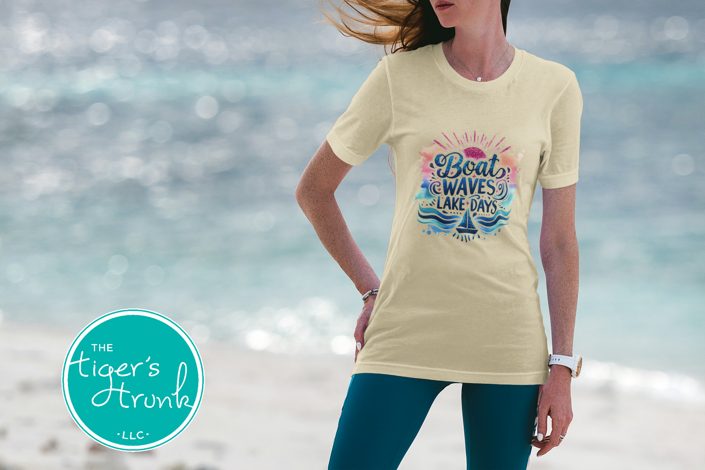 Person wearing a t-shirt with a colorful graphic design on a beach, featuring 'The Tiger's Trunk' logo.