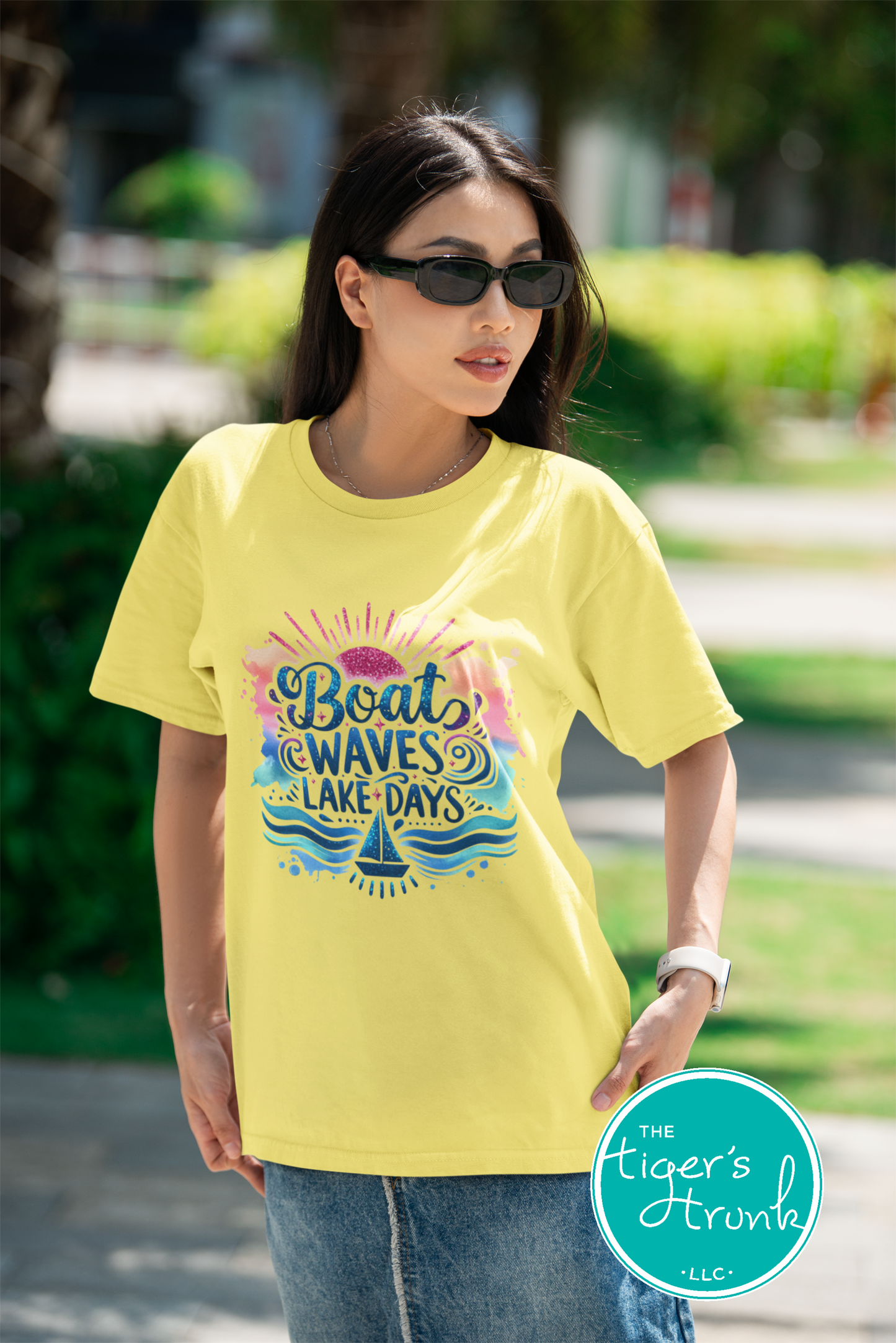 Woman wearing a yellow t-shirt with a colorful graphic and text, standing outdoors.