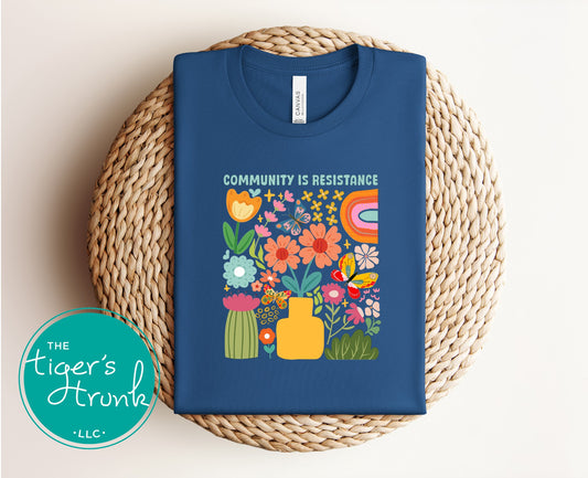 Graphic t-shirt with the phrase "Community Is Resistance," activist apparel for social justice supporters and movement organizers
