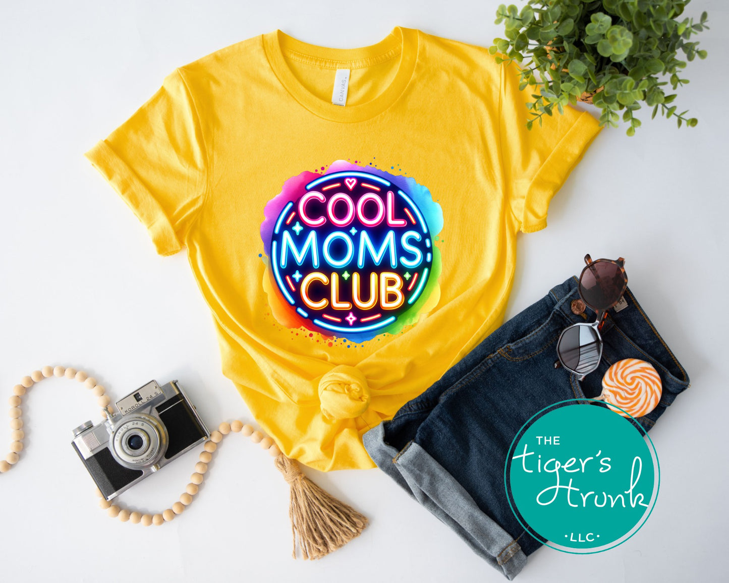 Graphic t-shirt with Cool Mom's Club text in neon colors, fun and trendy design for stylish moms