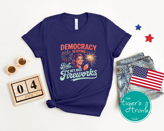 Patriotic graphic t-shirt that reads Democracy Is Dying But Hey, Nice Fireworks, political and sarcastic July Fourth shirt