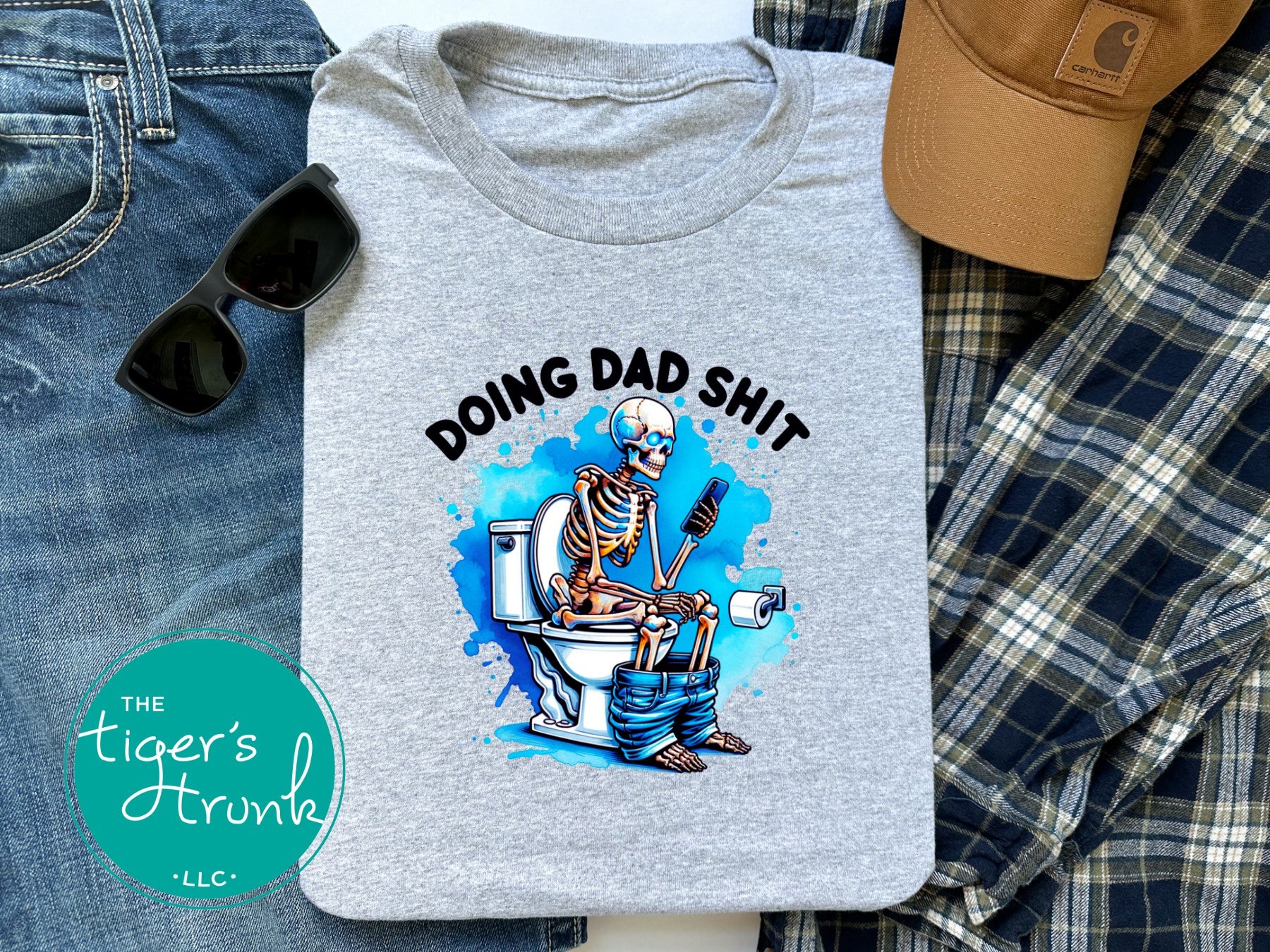 Skeleton sitting on a toilet with the phrase "Doing Dad Shit," printed on a t-shirt for dad humor and Father’s Day gifts