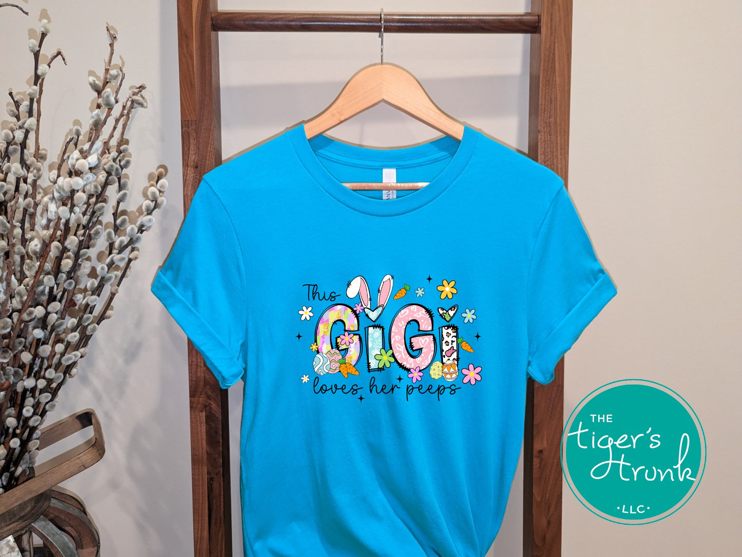 Easter t-shirt with "Gigi" in pastel spring print font including bunnies, florals, and Easter eggs, perfect for spring celebrations