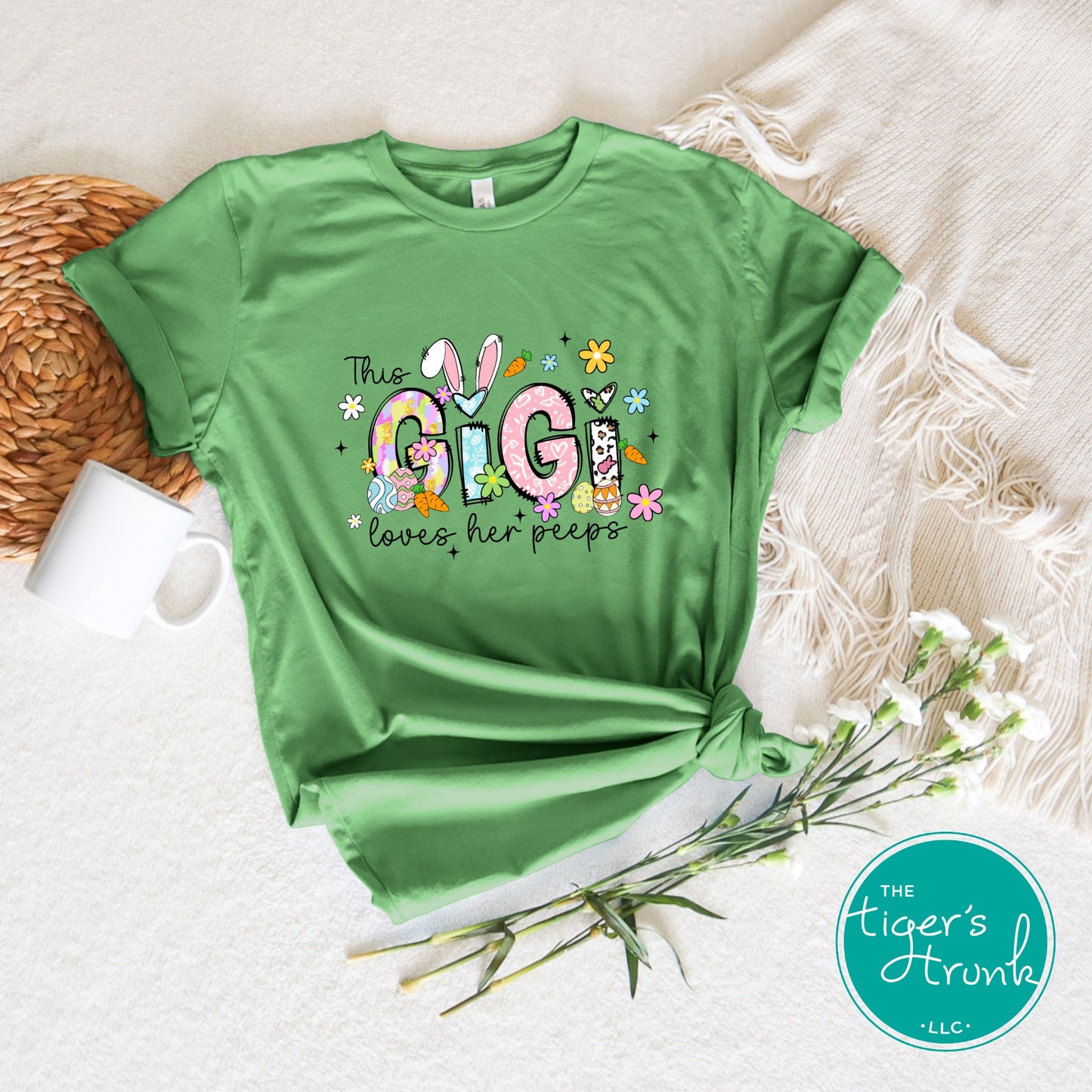 Easter t-shirt with "Gigi" in pastel spring print font including bunnies, florals, and Easter eggs, perfect for spring celebrations