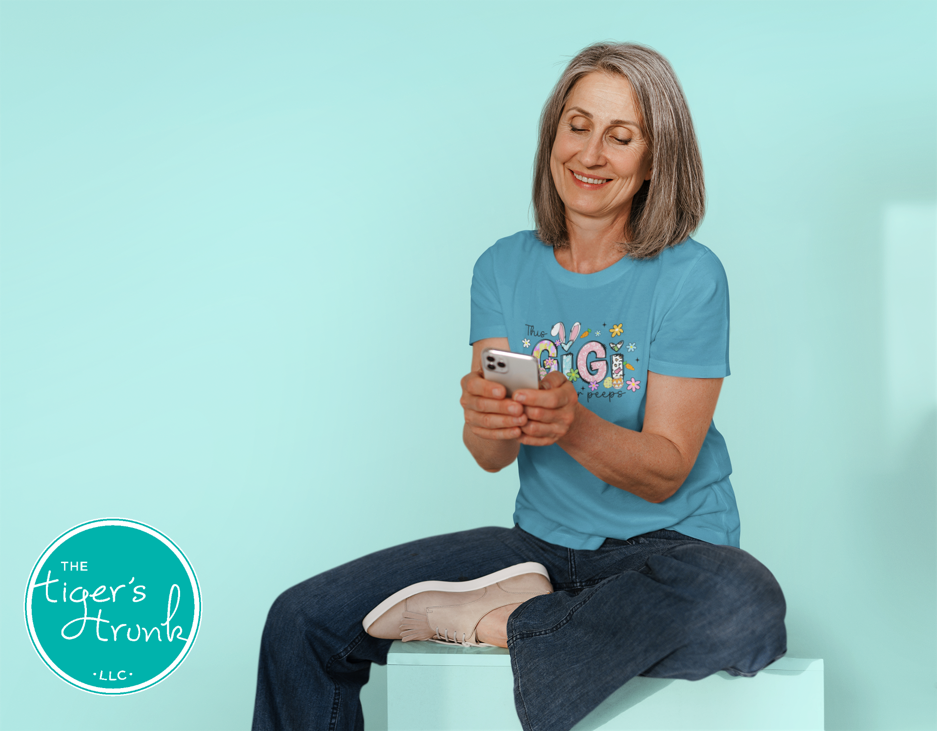 Easter t-shirt with "Gigi" in pastel spring print font including bunnies, florals, and Easter eggs, perfect for spring celebrations