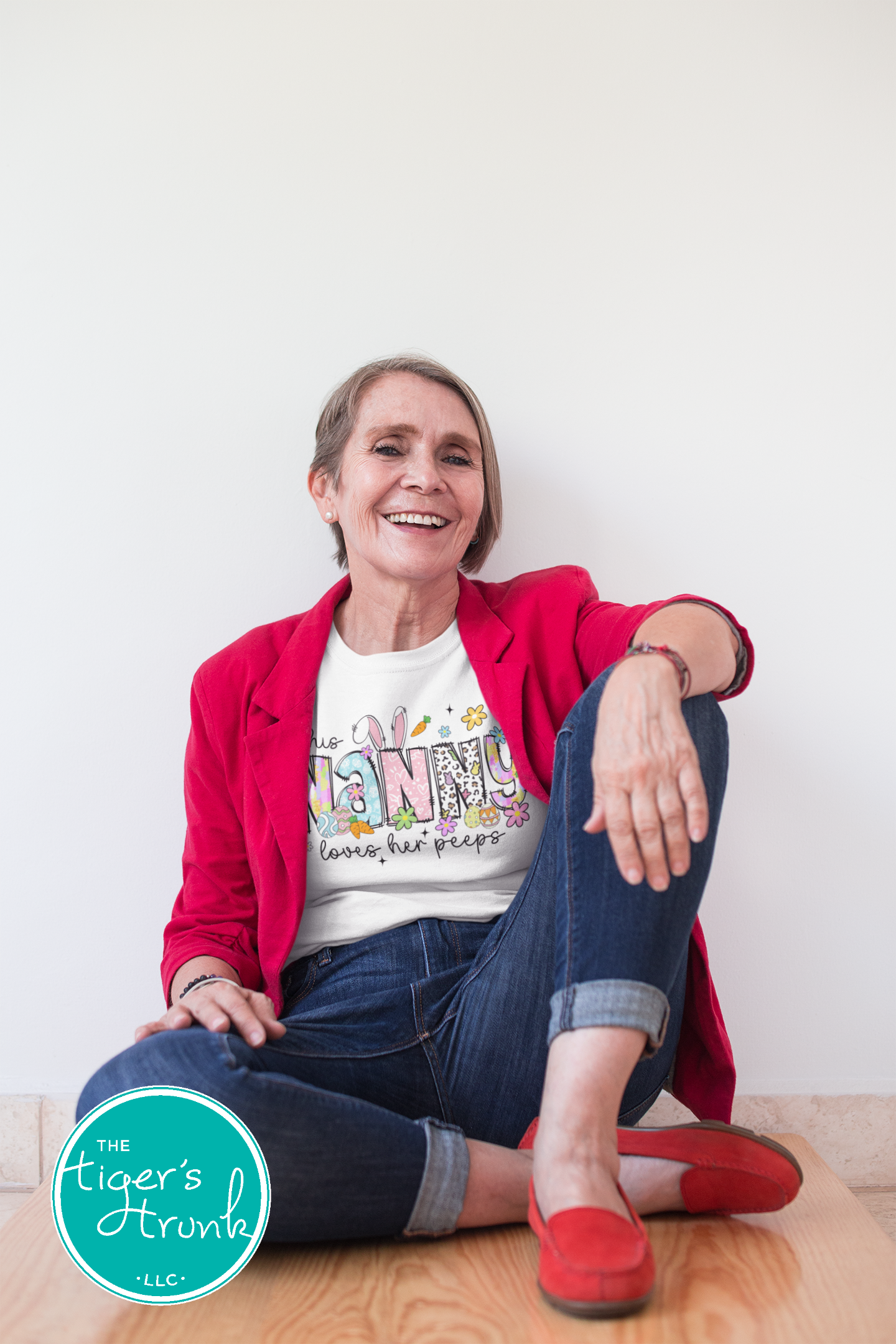 Easter t-shirt with "Nanny" in spring print font decorated with bunnies, eggs, and flowers, perfect for holiday wear and springtime fun