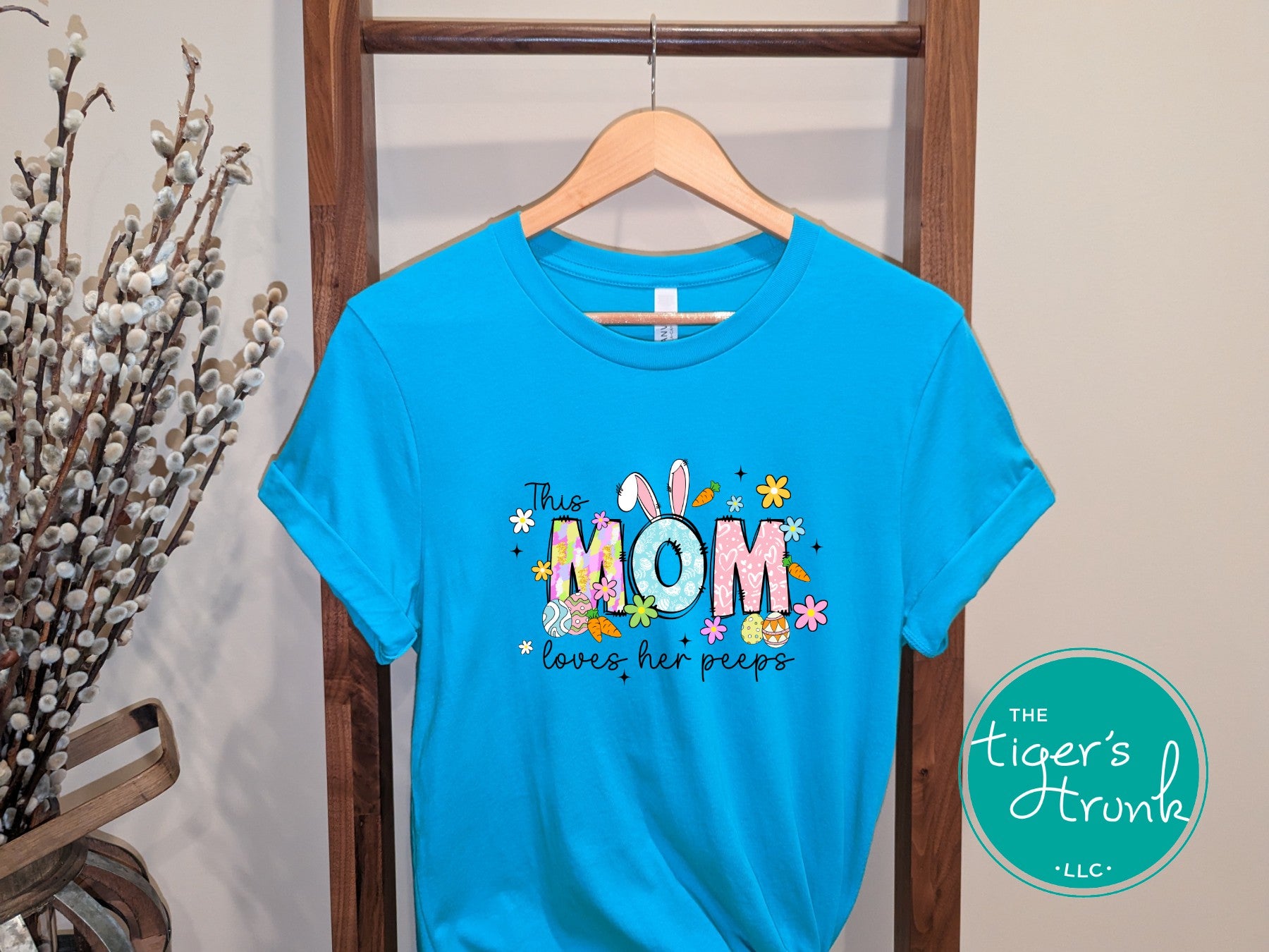 Easter t-shirt for Mom with spring-themed pastel font, featuring bunnies, flowers, and Easter prints in the word Mom