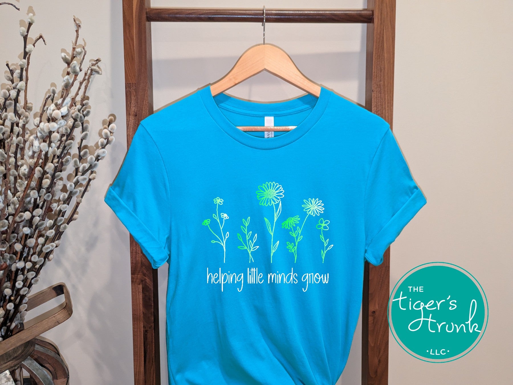 T-shirt with wildflowers and the phrase "Helping Little Minds Grow," a soft and inspiring design for educators and school staff