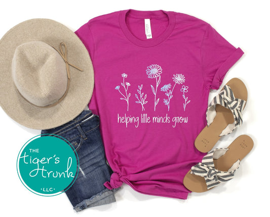 T-shirt with wildflowers and the phrase "Helping Little Minds Grow," a soft and inspiring design for educators and school staff