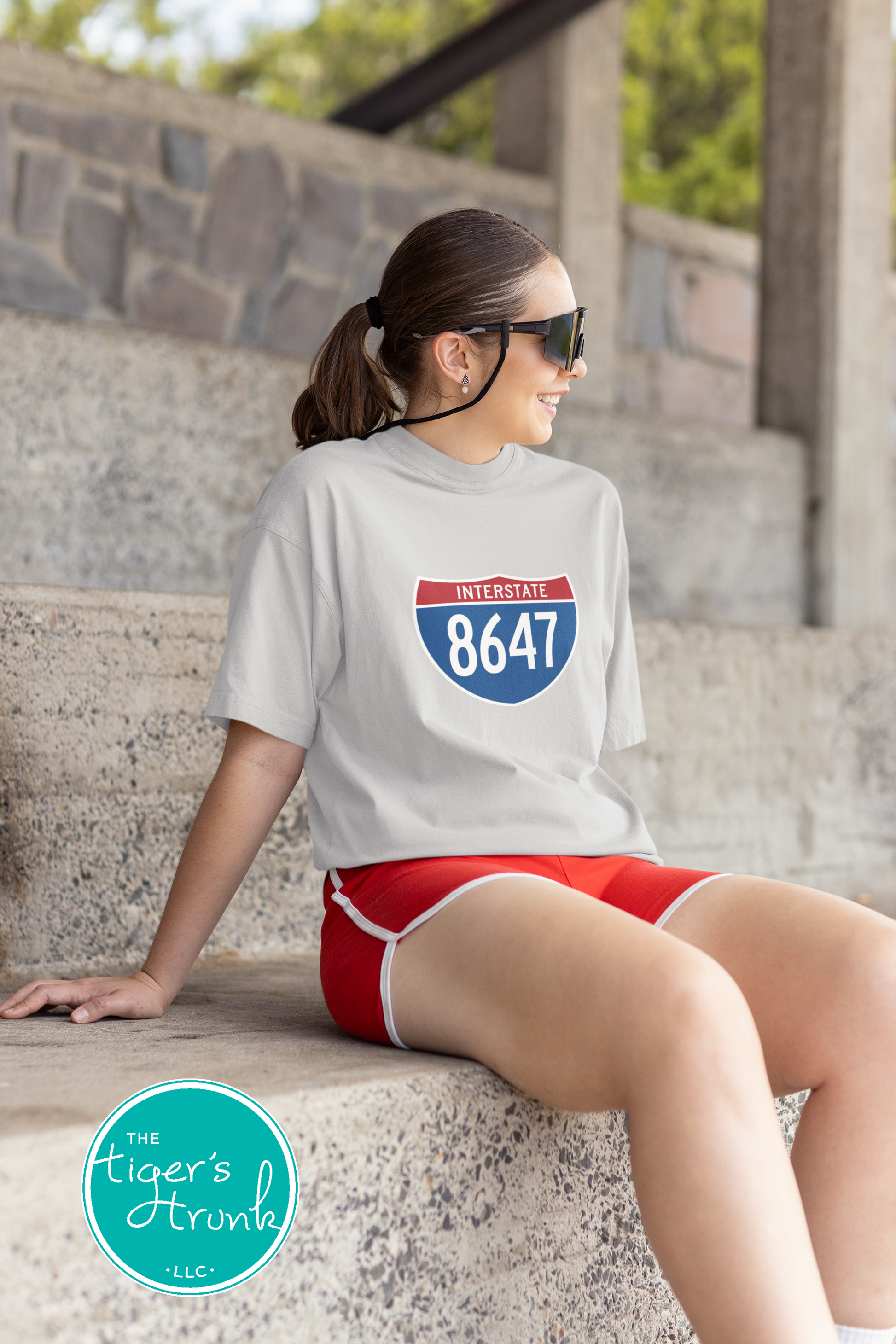 T-shirt featuring 8647 inside an Interstate sign, clean and bold design with a subtle political message