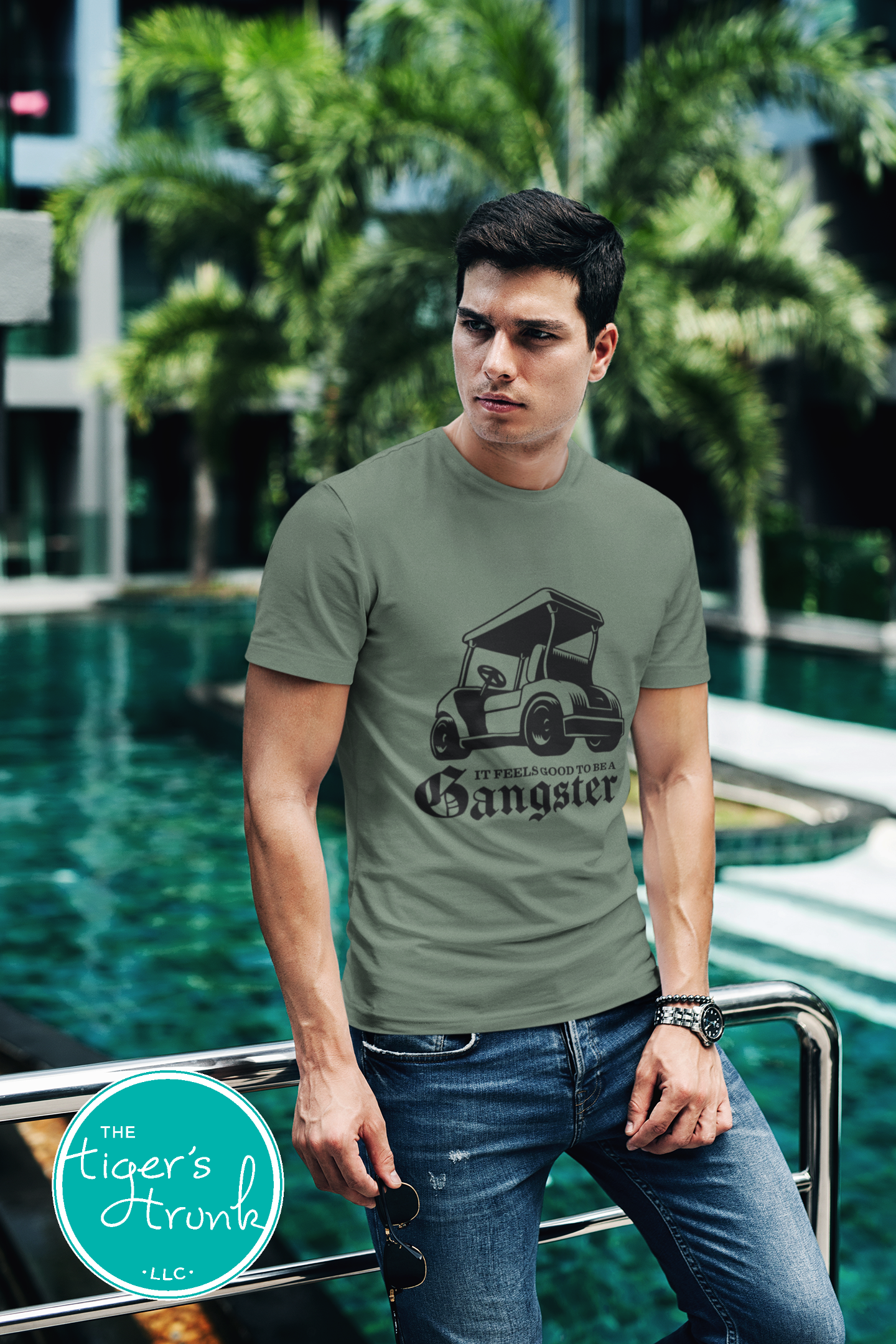 Male model wearing military green golf cart shirt with black graphic that says It Feels Good to Be a Gangster, funny golf tee for men