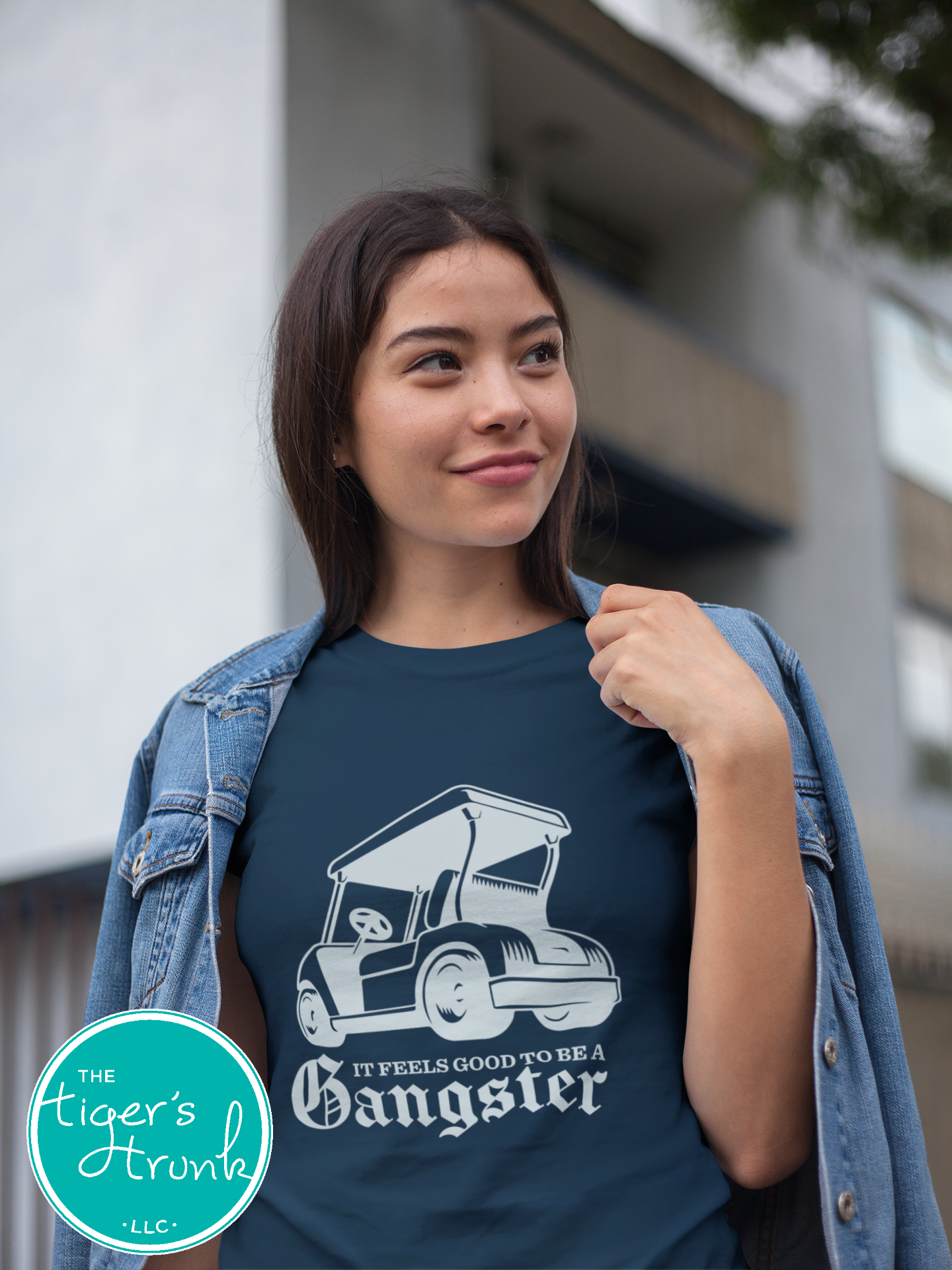 Female model wearing navy golf cart shirt with light blue graphic that says It Feels Good to Be a Gangster, funny golf shirt for women, golfer gift