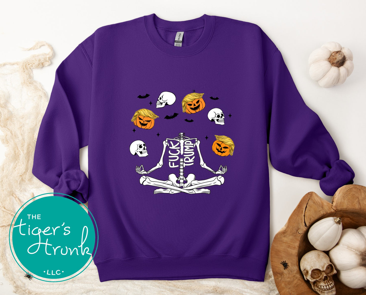 Purple sweatshirt with Halloween-themed design on a white background with pumpkins and skulls.