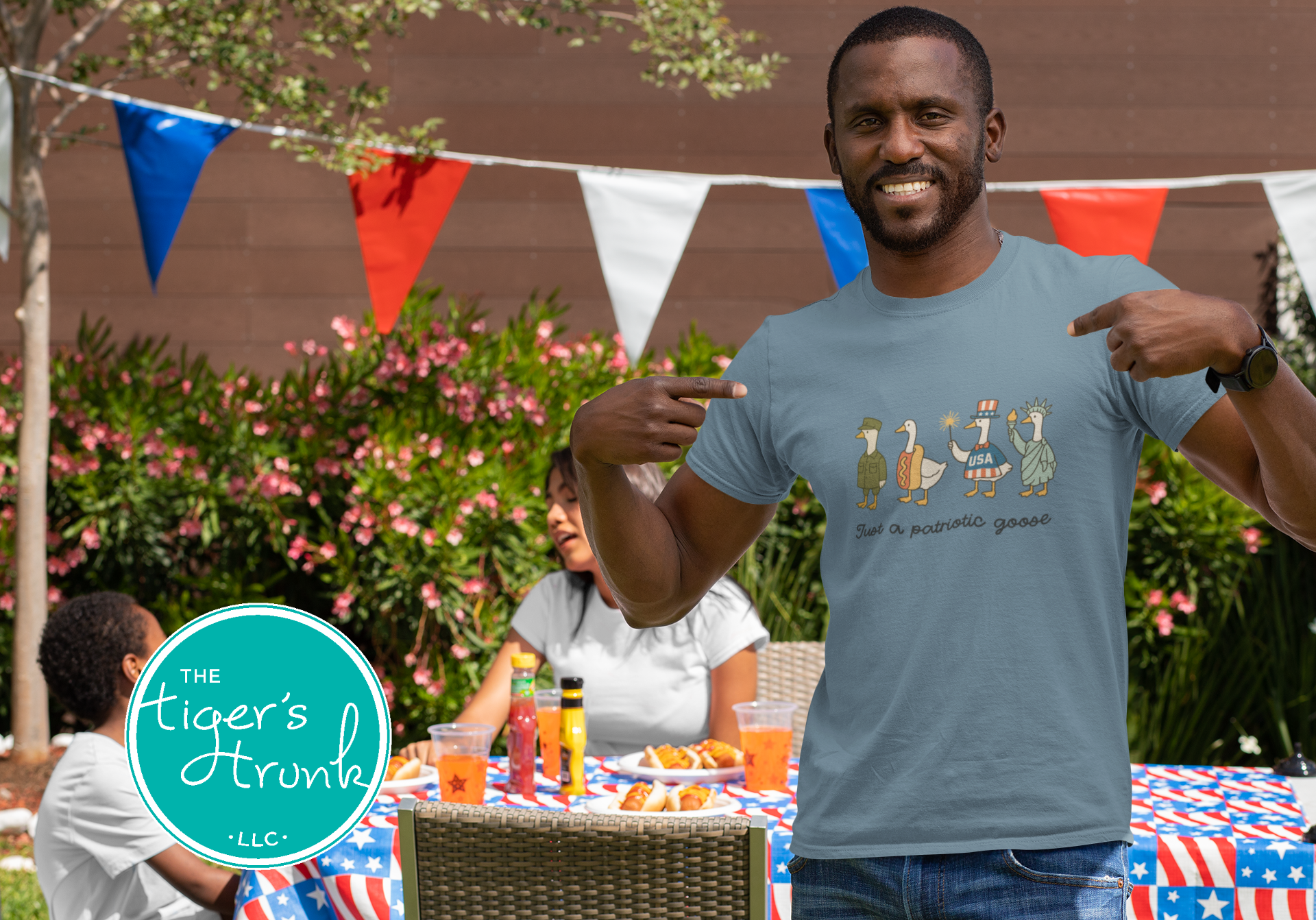 Funny patriotic t-shirt with four geese dressed as a soldier, hotdog, statue, and red-white-blue icon, reading Just a Patriotic Goose