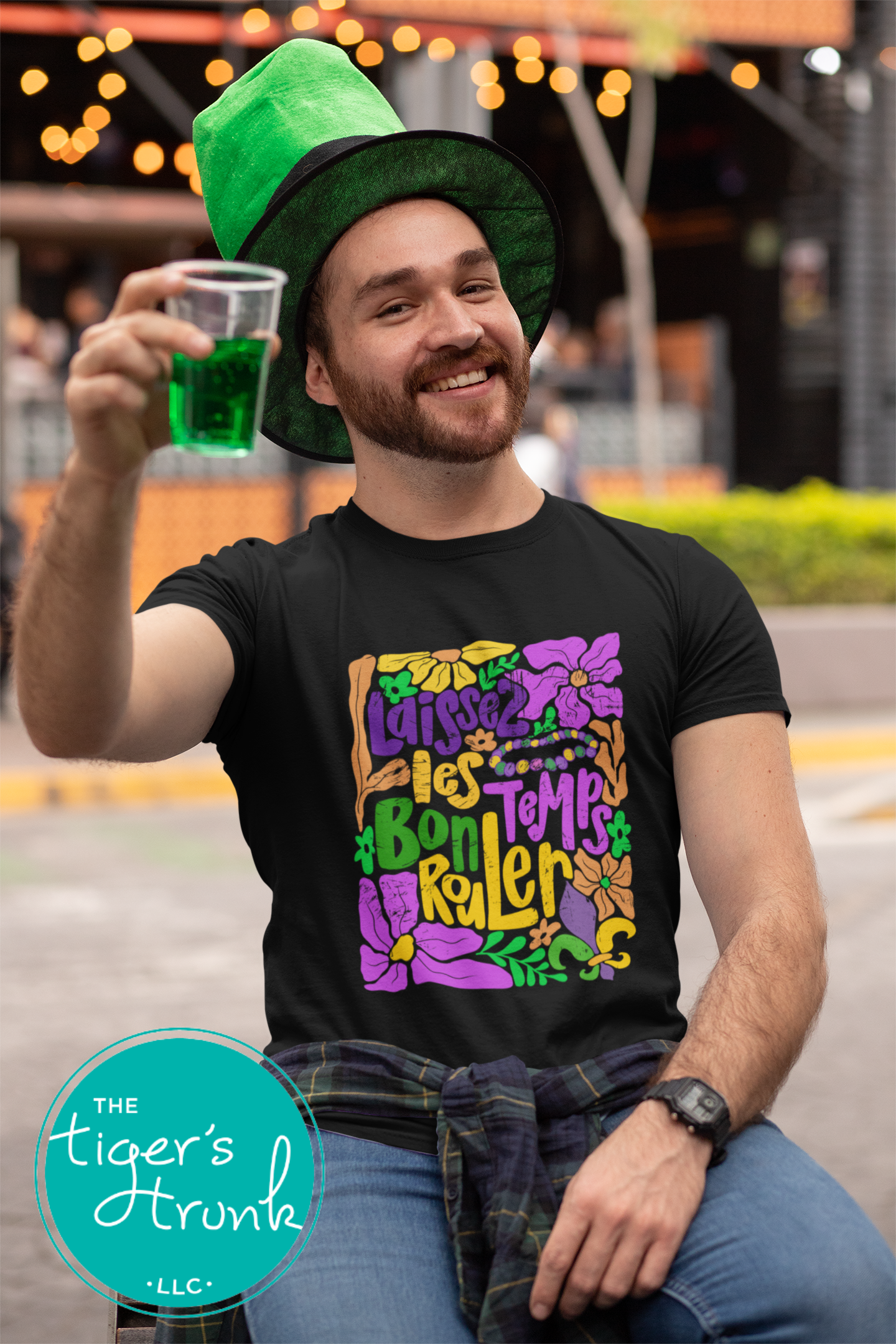 Tropical vintage-style Mardi Gras t-shirt with the phrase "Laissez les Bon Temps Rouler" in classic purple, green, and gold colors.