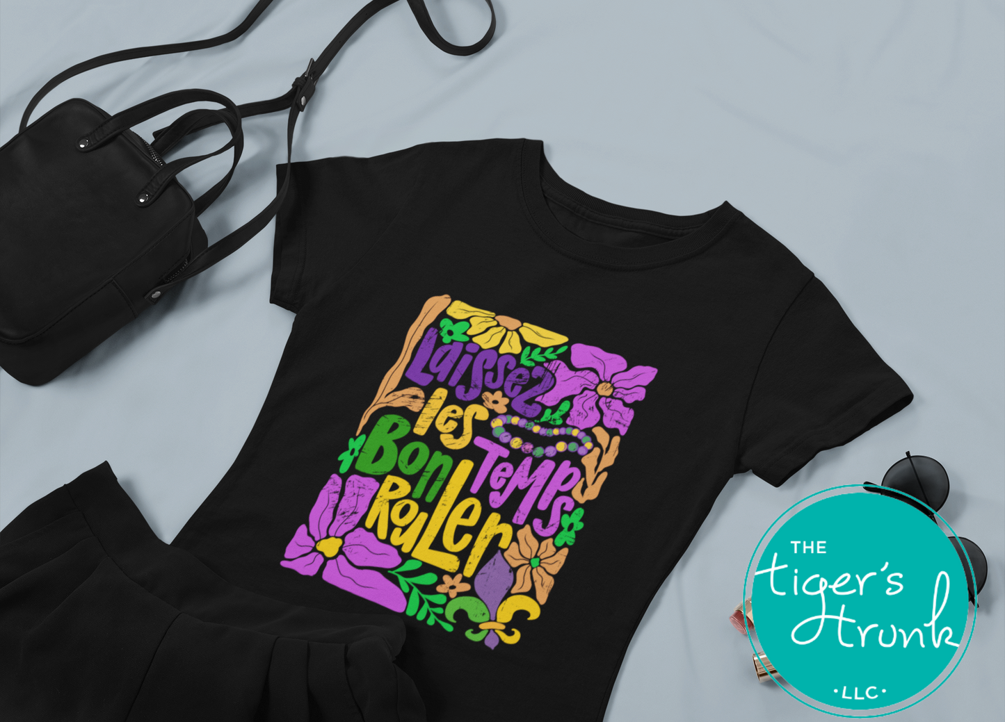 Tropical vintage-style Mardi Gras t-shirt with the phrase "Laissez les Bon Temps Rouler" in classic purple, green, and gold colors.