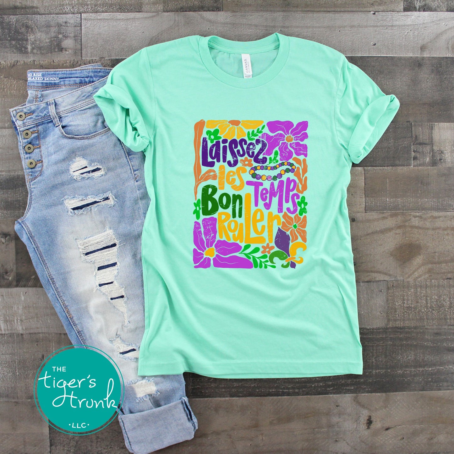 Tropical vintage-style Mardi Gras t-shirt with the phrase "Laissez les Bon Temps Rouler" in classic purple, green, and gold colors.