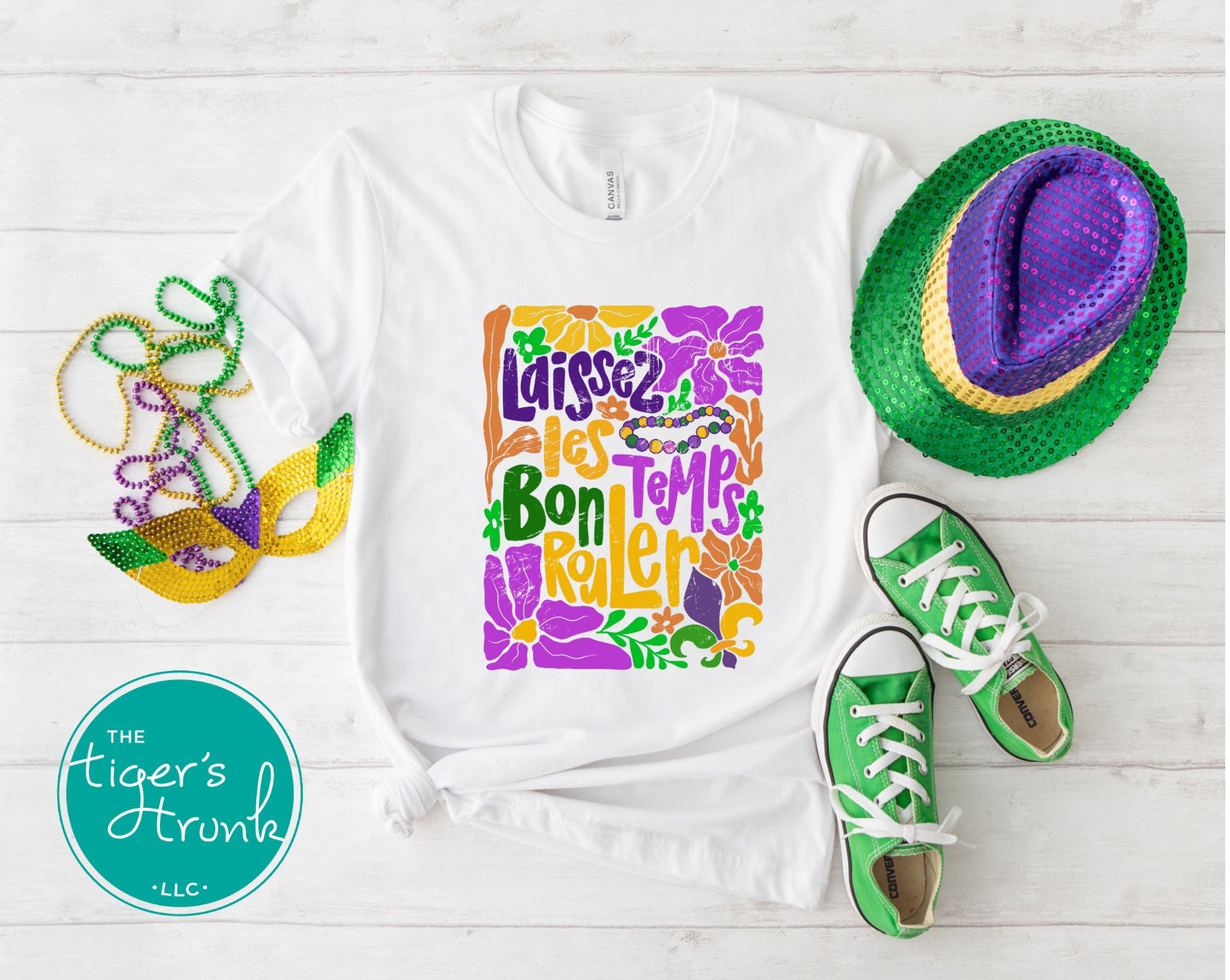 Tropical vintage-style Mardi Gras t-shirt with the phrase "Laissez les Bon Temps Rouler" in classic purple, green, and gold colors.