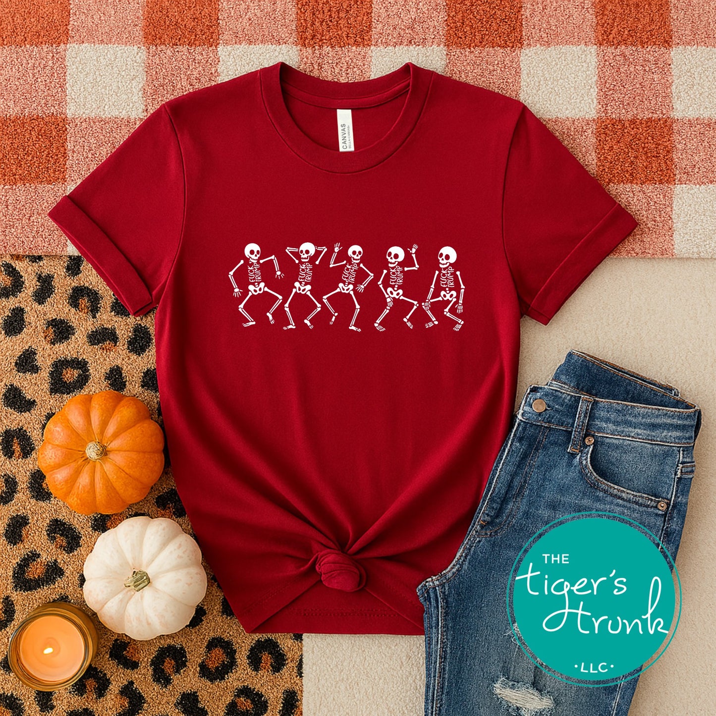 Red t-shirt with skeleton design on a checkered background with pumpkins and jeans.