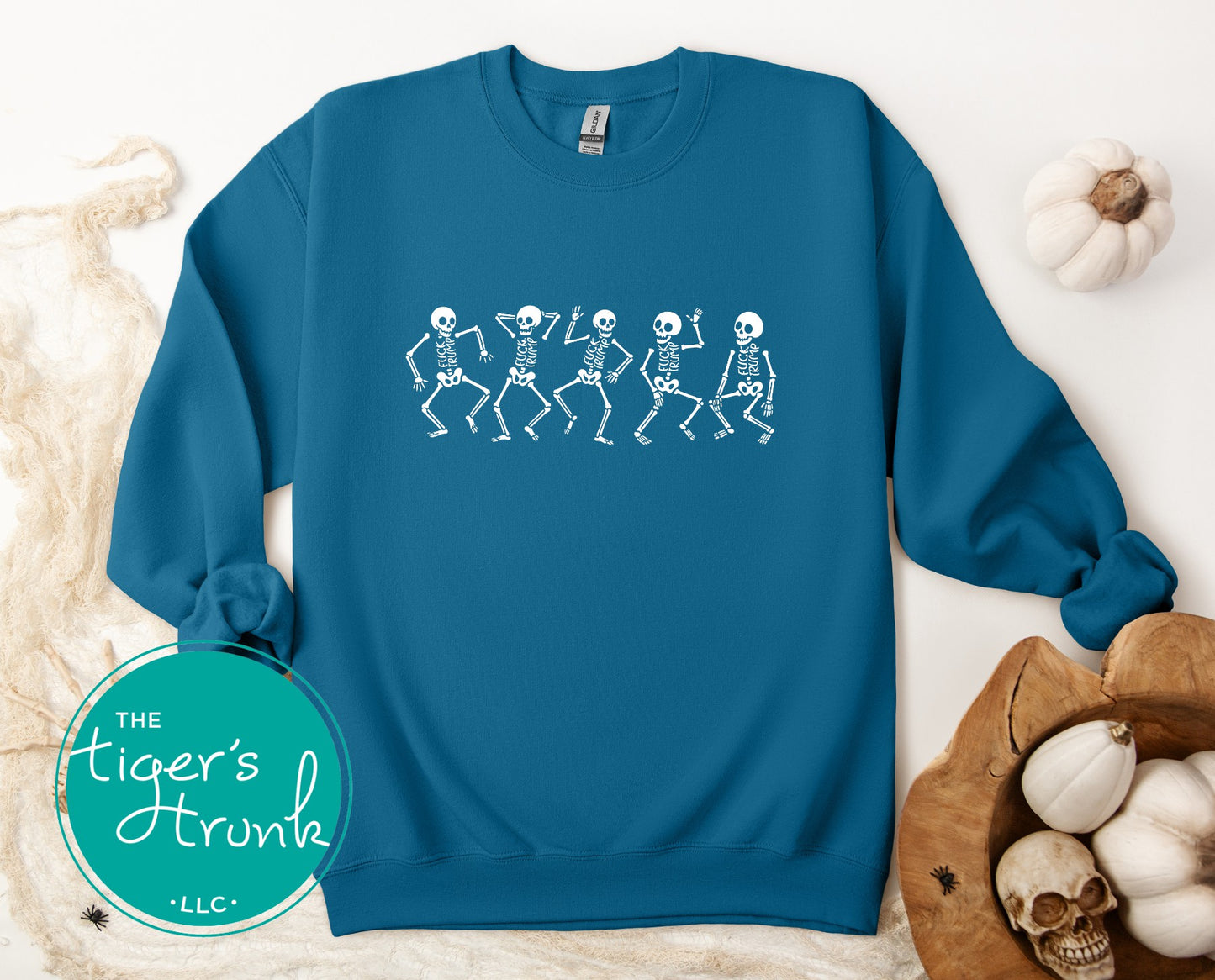 Blue sweatshirt with skeleton design on a white surface with decorative items.