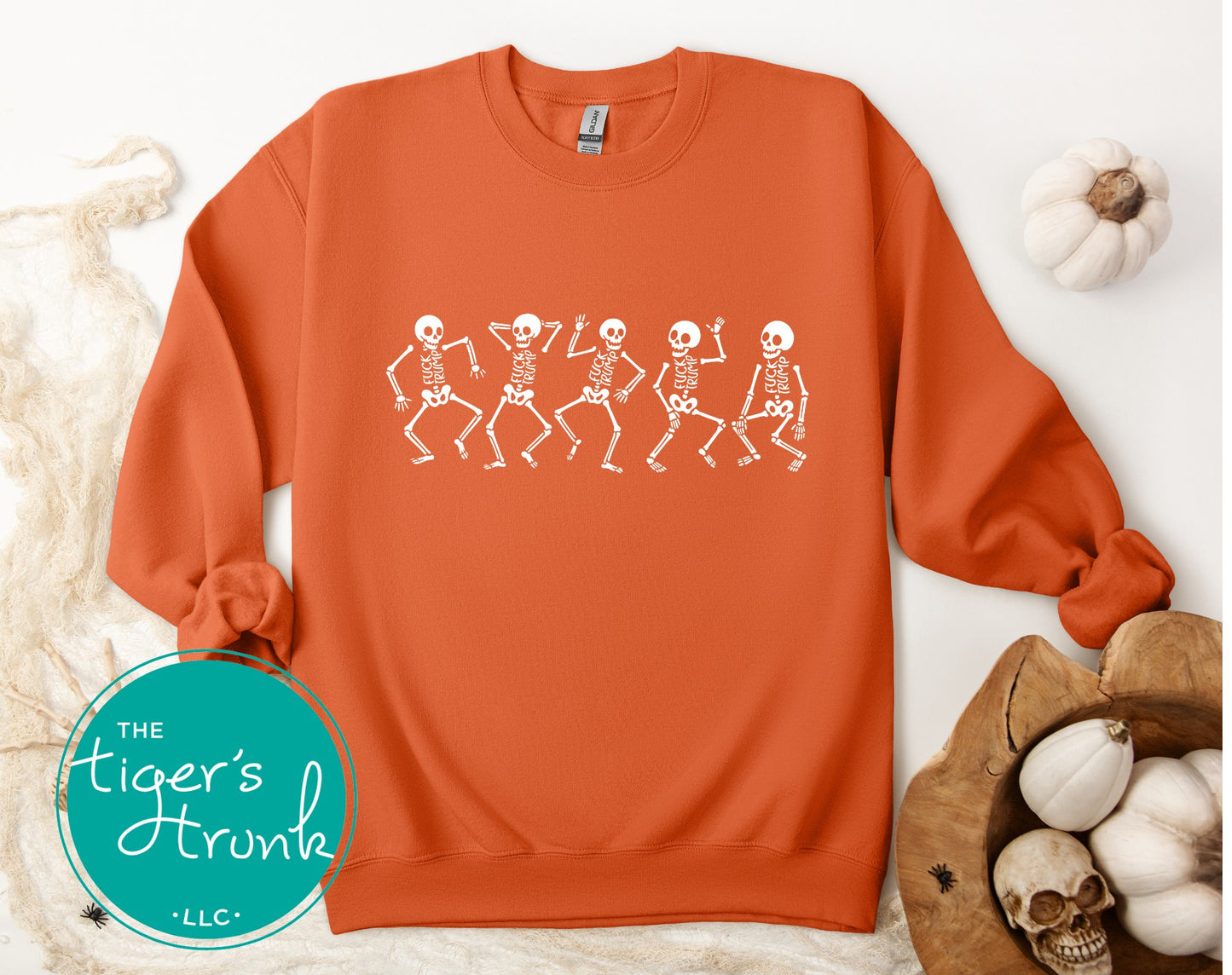 Orange sweatshirt with skeleton design on a white background, featuring 'The Tiger's Trunk' brand.