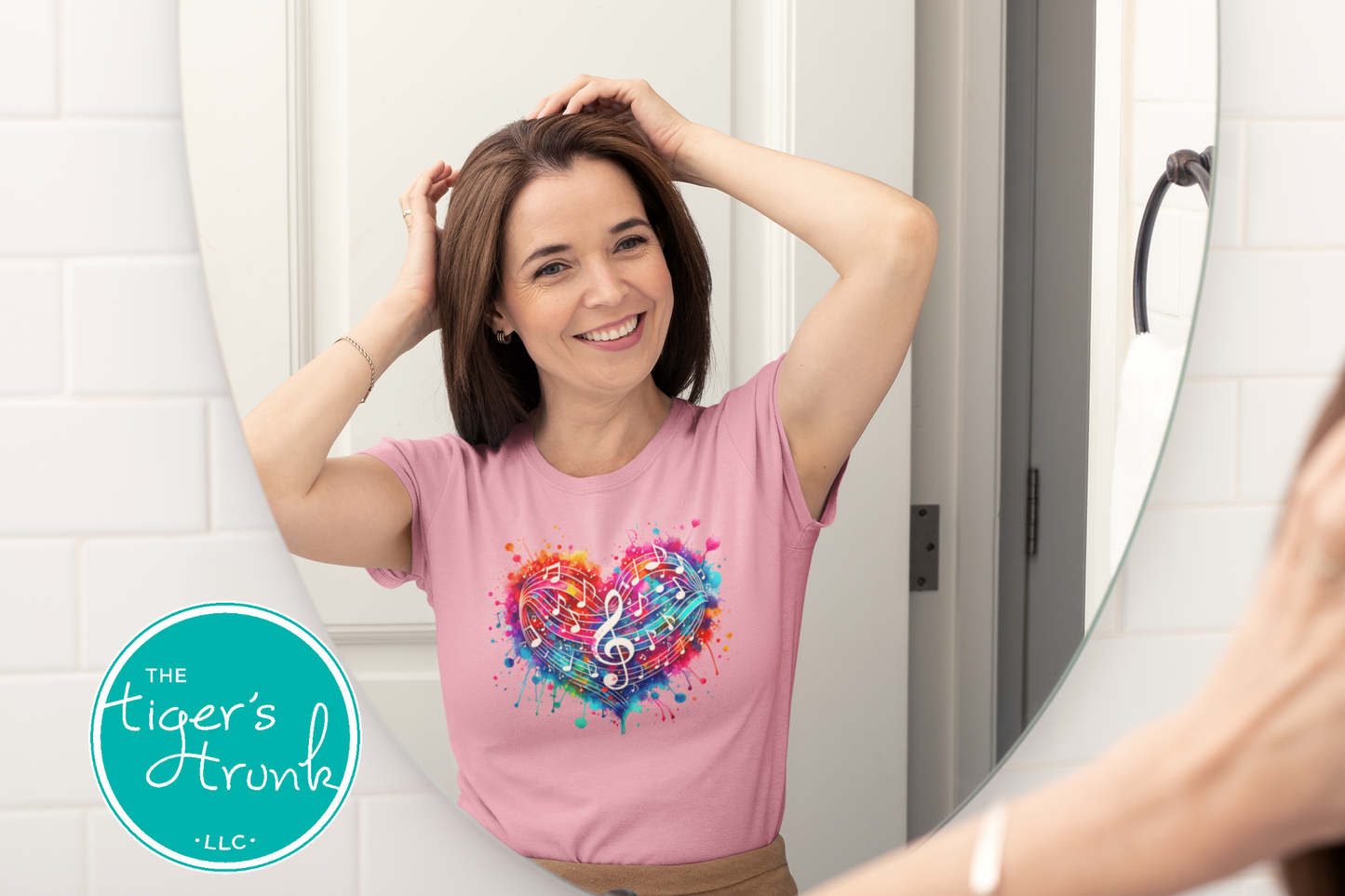 Woman wearing a pink t-shirt with a colorful heart design, standing in front of a mirror.