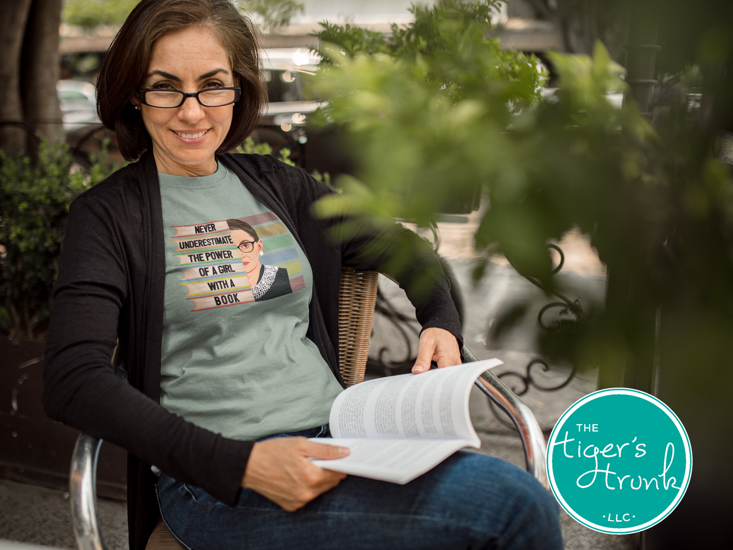 Woman reading a book outdoors with 'The Tiger's Den' logo in the corner.