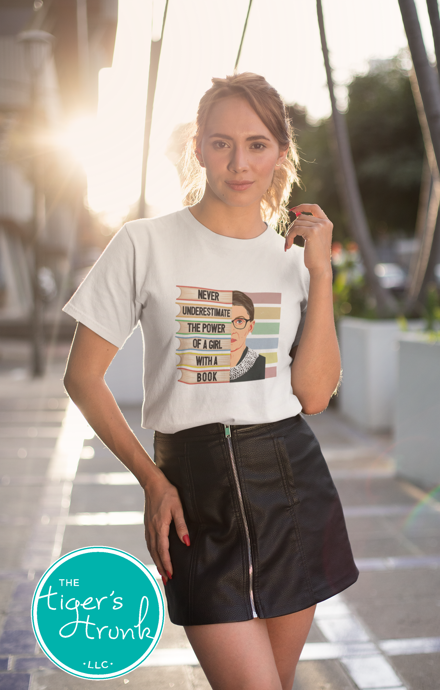 Woman wearing a white t-shirt with a graphic design, standing outdoors.