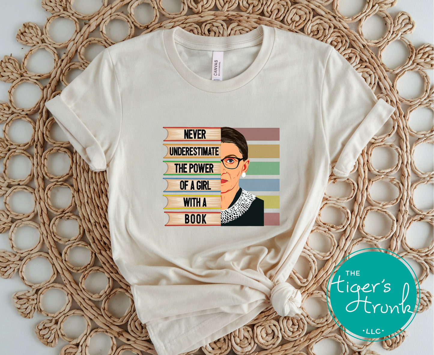 White t-shirt with a graphic design and text on a textured surface, featuring 'The Tiger's Trunk' logo.