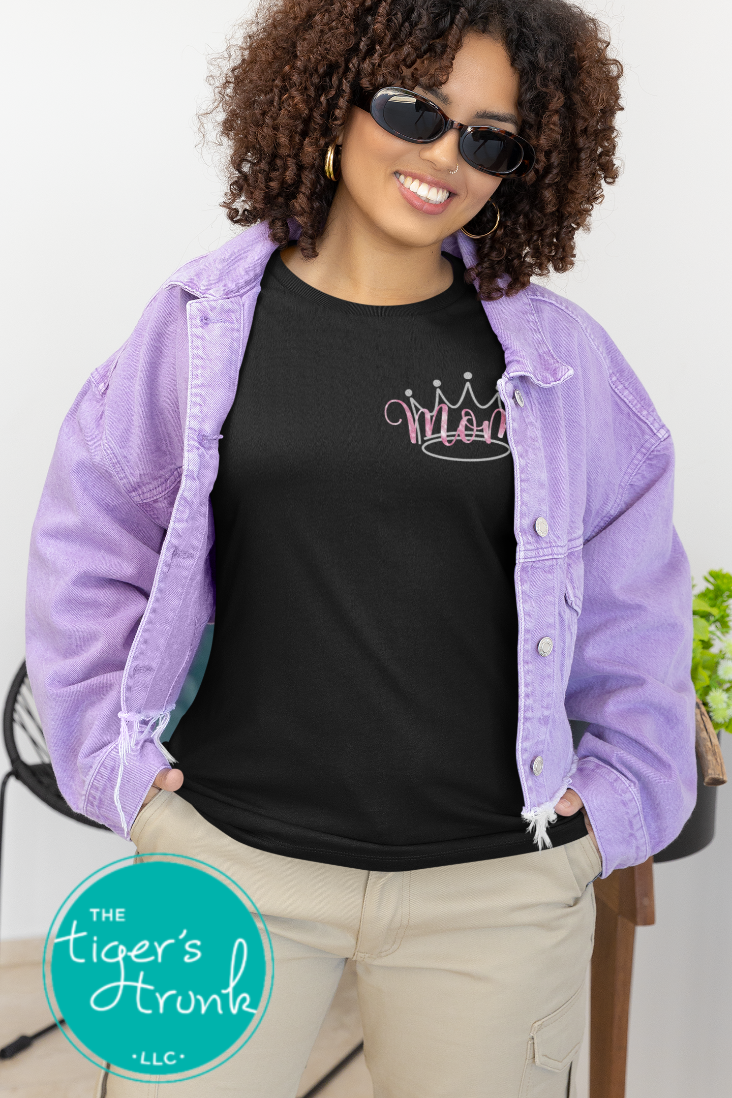 Model wearing black pageant mom shirt with pink crown and “Mom” in script font on the front, personalized on the back with contestant’s name in block letters
