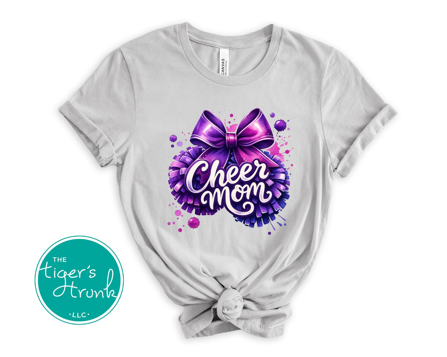Gray t-shirt with a purple bow and 'Cheer Mom' text on a white background, featuring The Tiger's Trunk logo.