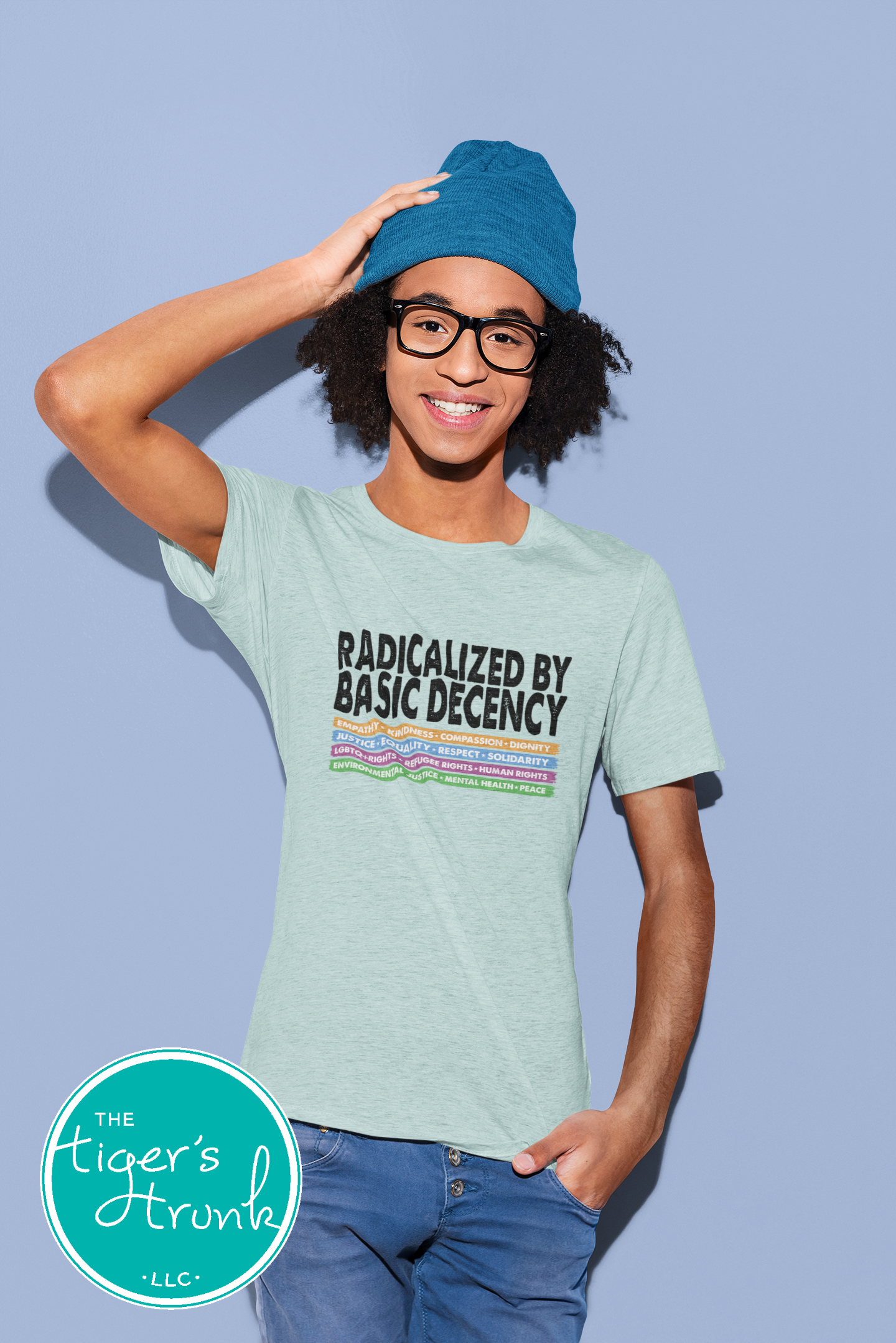 Person wearing a light green t-shirt with text and a blue beanie against a light blue background