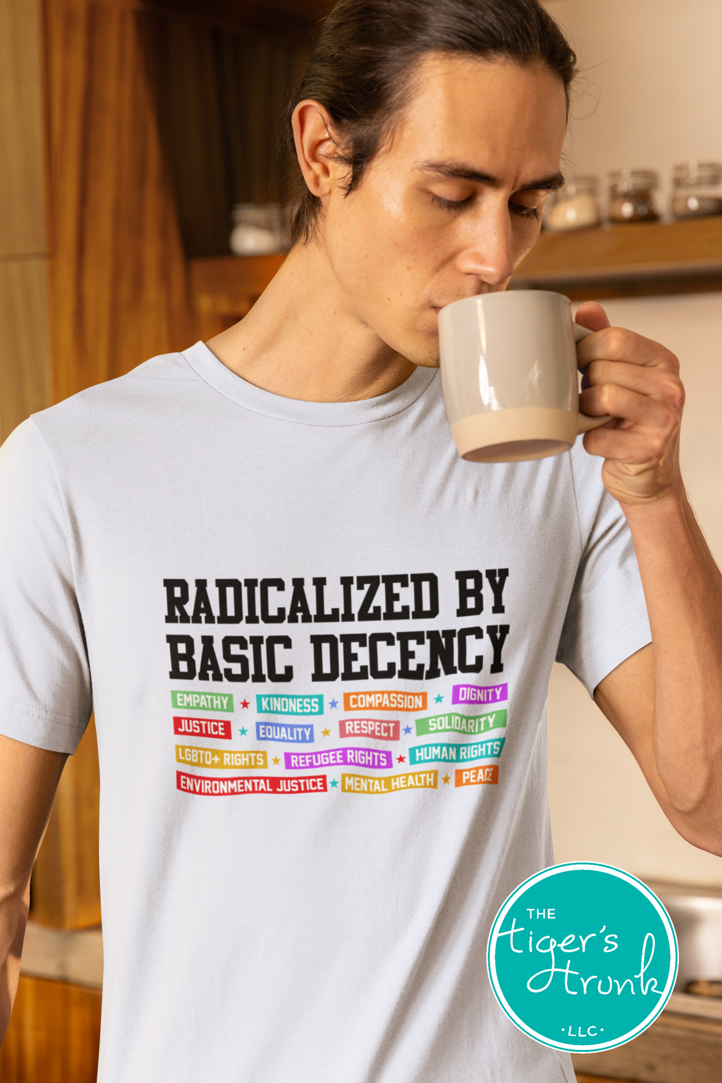 Person wearing a t-shirt with 'Radicalized by Basic Decency' text and drinking from a mug.