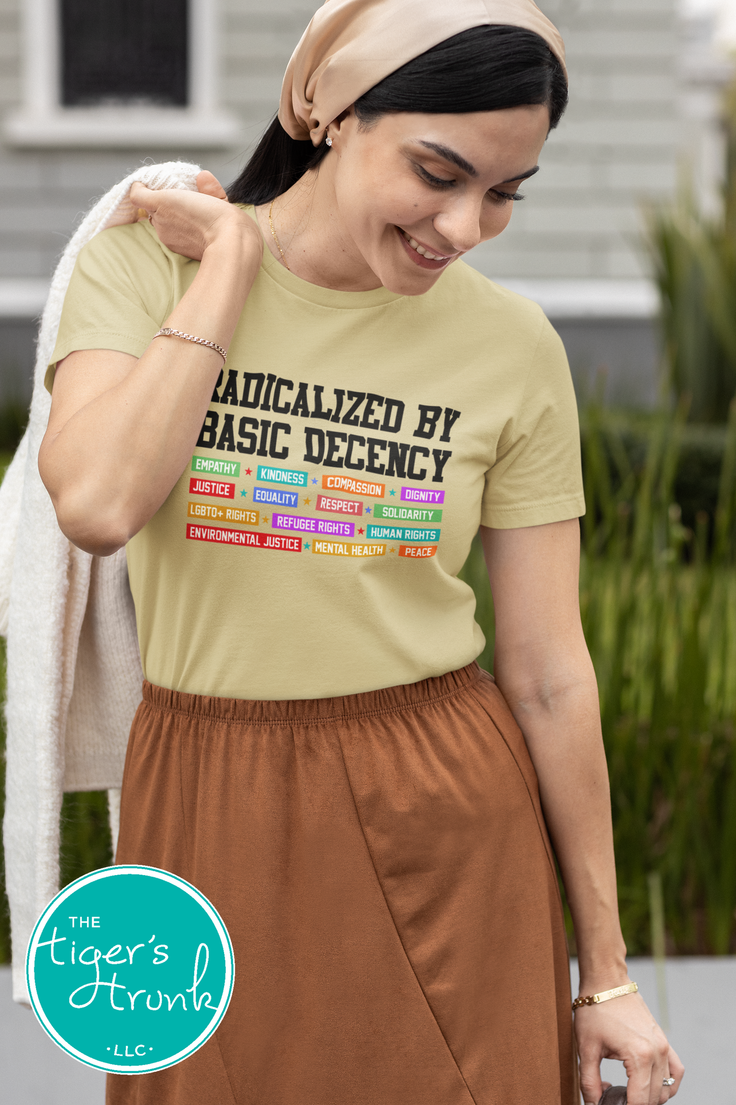 Woman wearing a t-shirt with text and colorful graphics, standing outdoors.