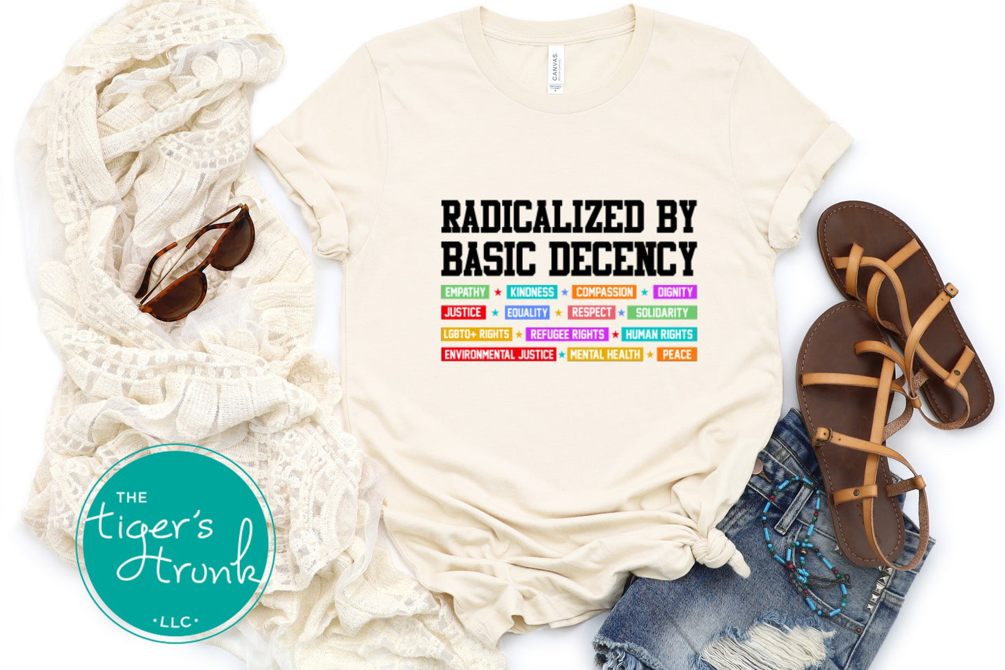 Beige t-shirt with colorful text, scarf, sandals, and jeans on a white background