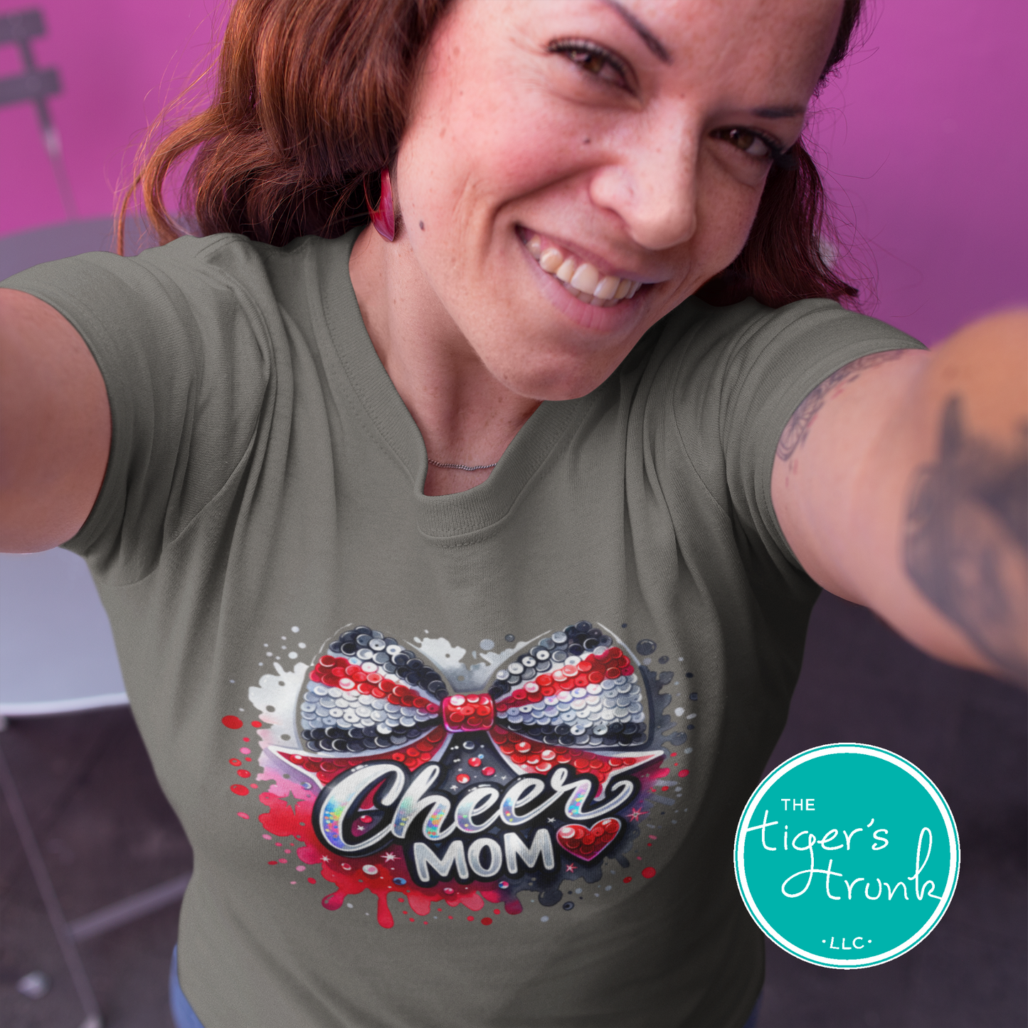 Woman wearing a green t-shirt with a 'Cheer Mom' design, standing against a purple background.