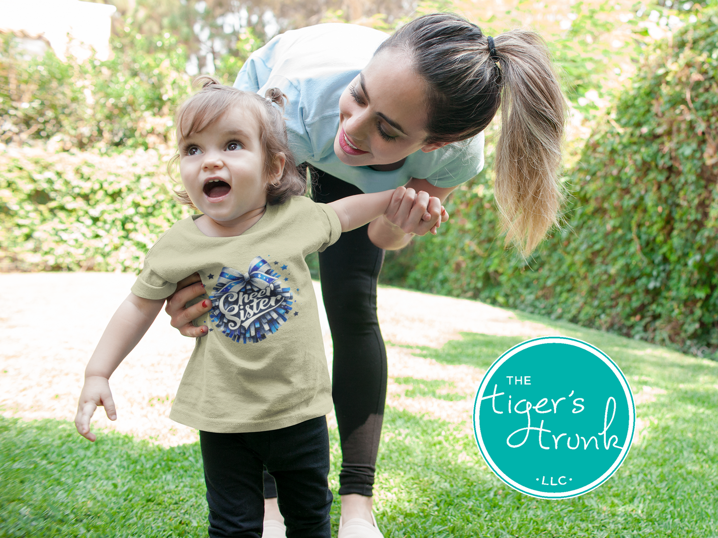 Woman and child outdoors with 'The Tiger's Trunk' logo