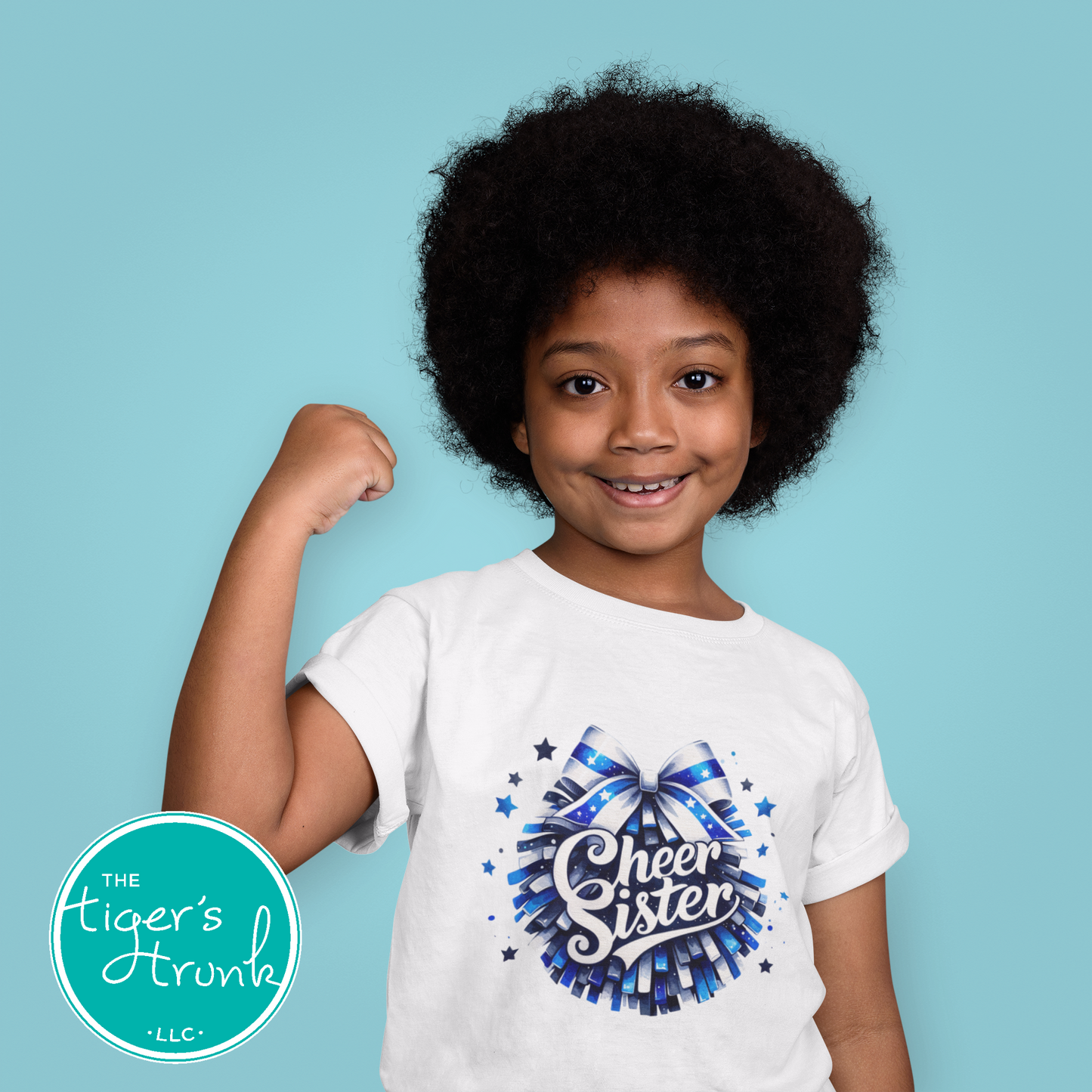 Child wearing a 'Cheer Sister' t-shirt with a blue bow design on a blue background, featuring the brand 'The Tiger's Strut'.