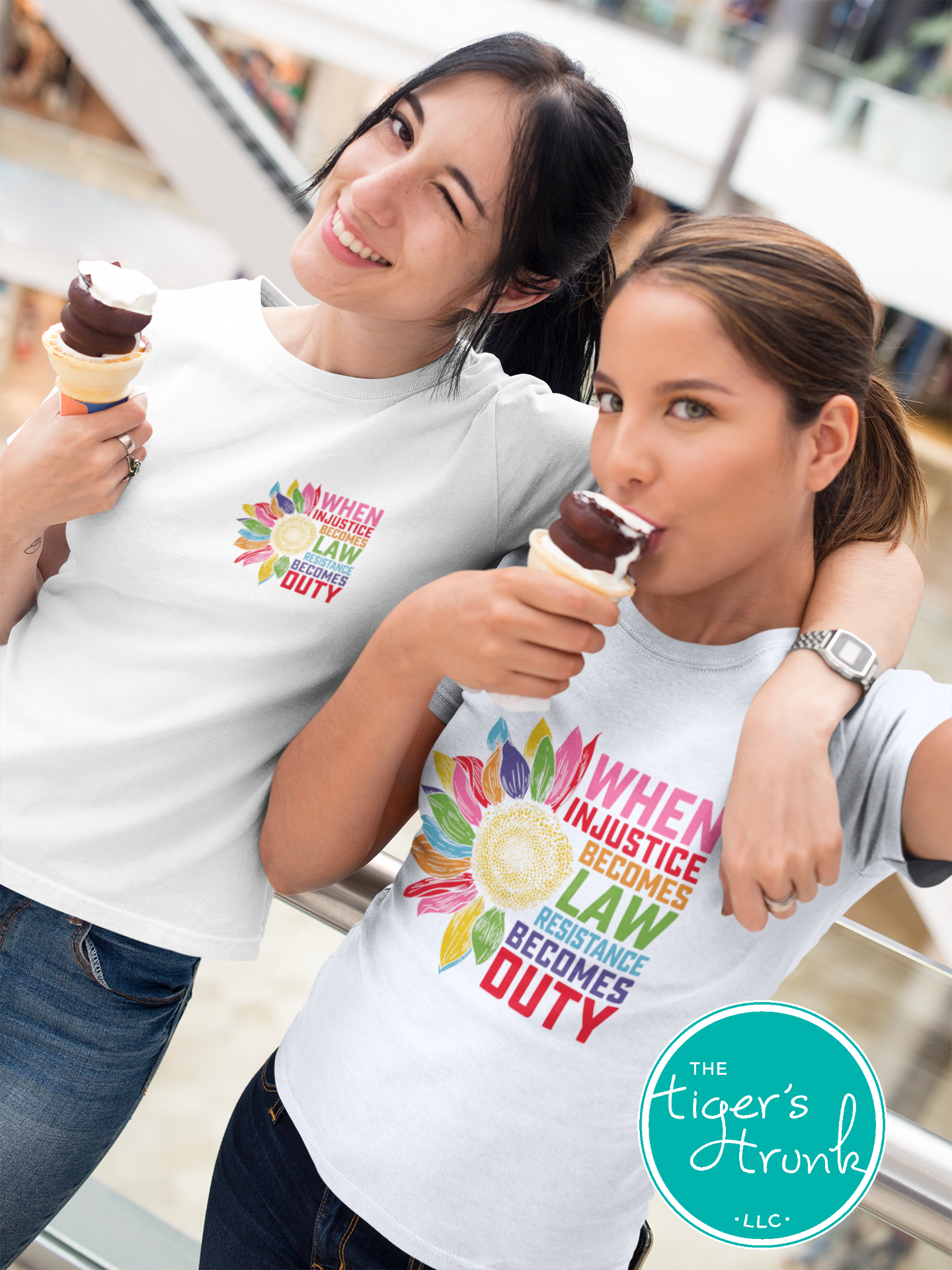 Two people wearing t-shirts with a colorful graphic and text, eating ice cream.