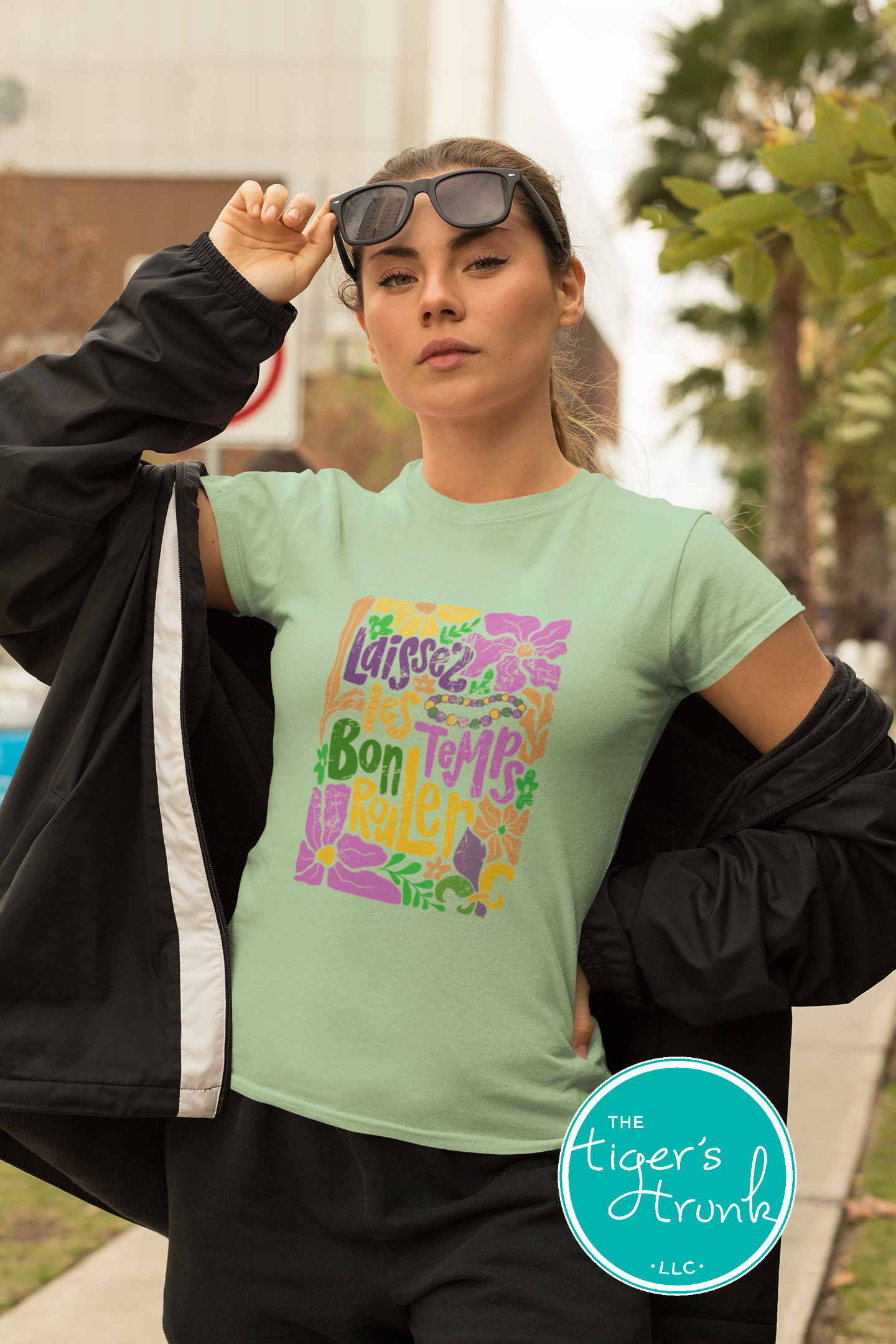 Tropical vintage-style Mardi Gras t-shirt with the phrase "Laissez les Bon Temps Rouler" in classic purple, green, and gold colors.