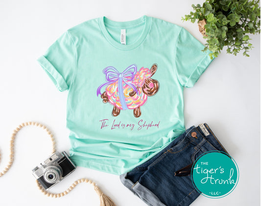 Christian Easter t-shirt with watercolor sheep and Psalm 23:1, featuring the verse "The Lord is my shepherd" in soft, faith-inspired design.