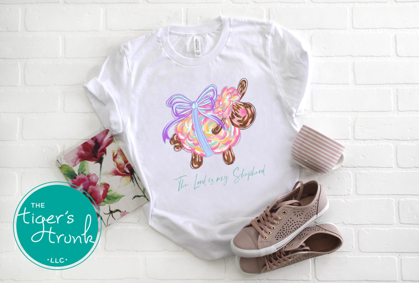 Christian Easter t-shirt with watercolor sheep and Psalm 23:1, featuring the verse "The Lord is my shepherd" in soft, faith-inspired design.