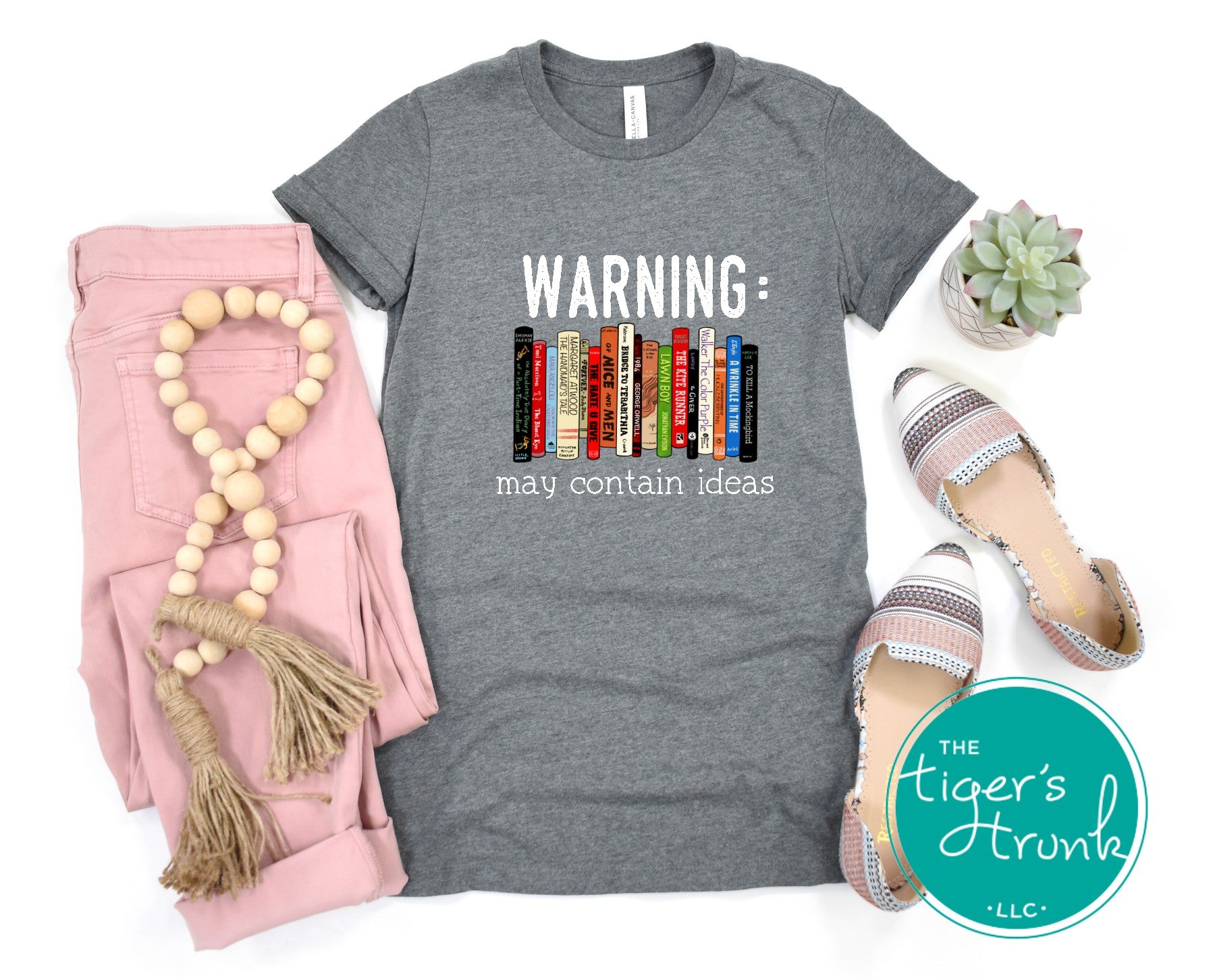 Graphic t-shirt featuring banned books and the phrase "Warning: May Contain Ideas," ideal for librarians, educators, and book lovers