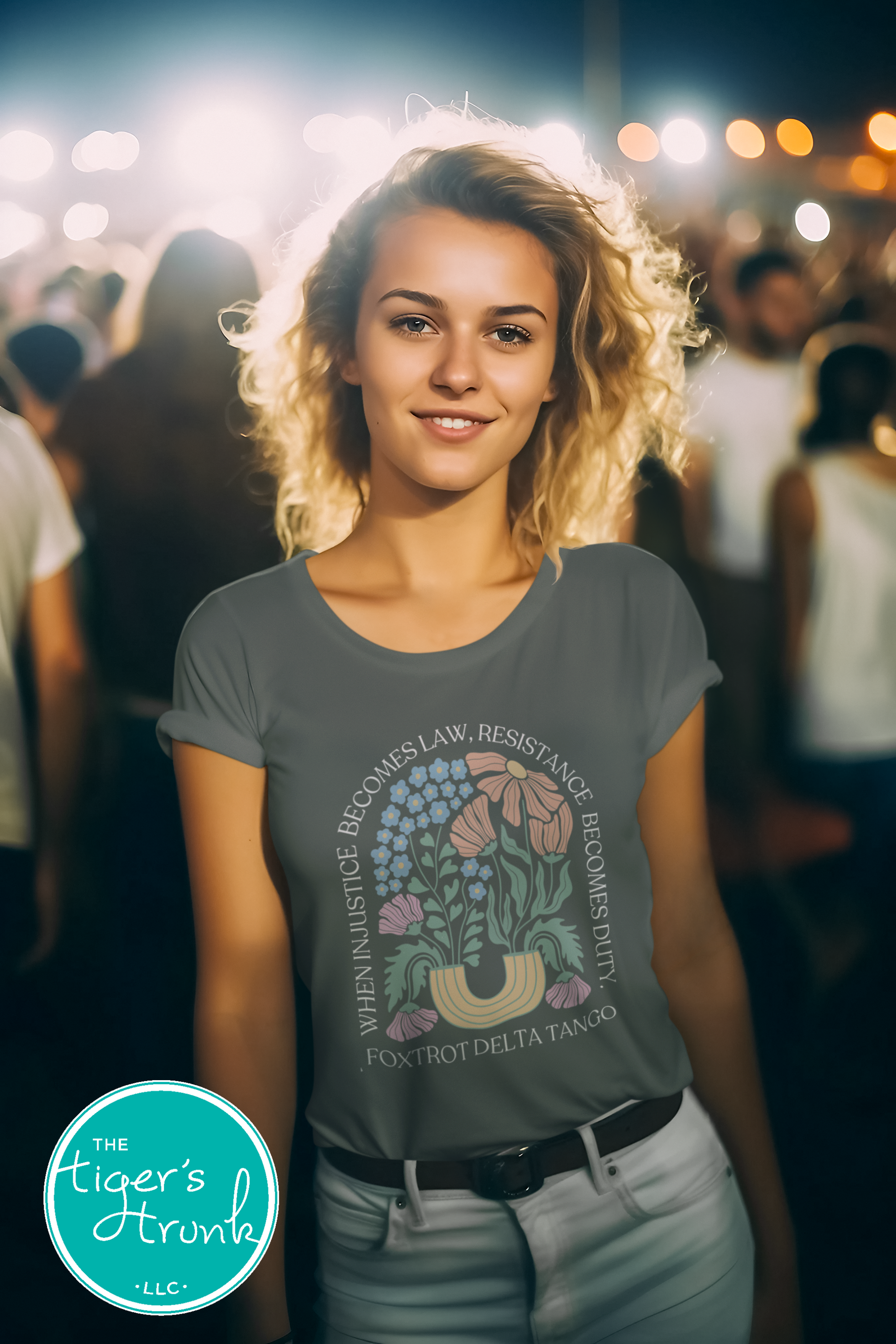 Woman wearing a t-shirt with a design and text, standing in a crowd at night.