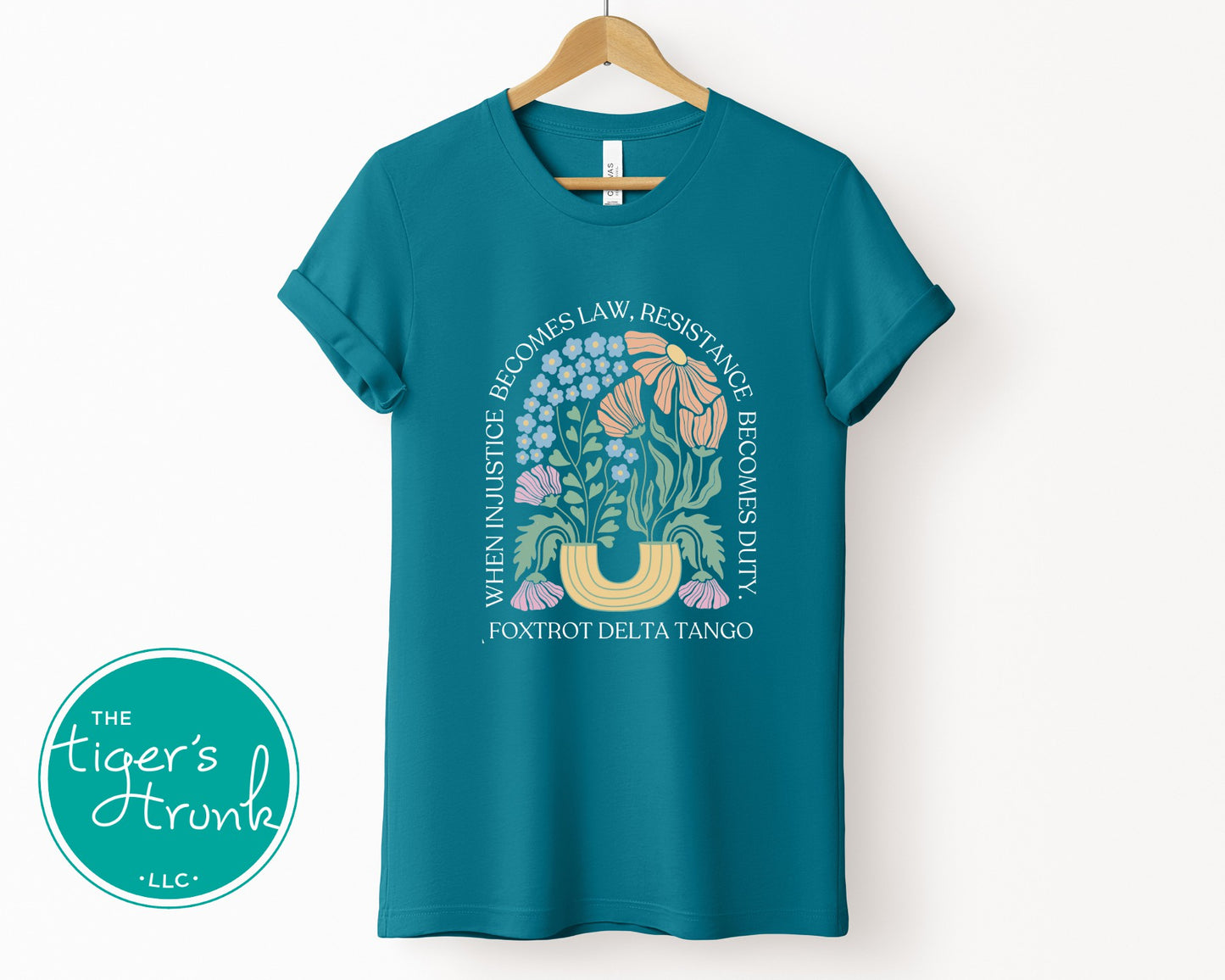 Teal t-shirt with graphic design and text on a white background, featuring 'The Tiger's Trunk' logo.