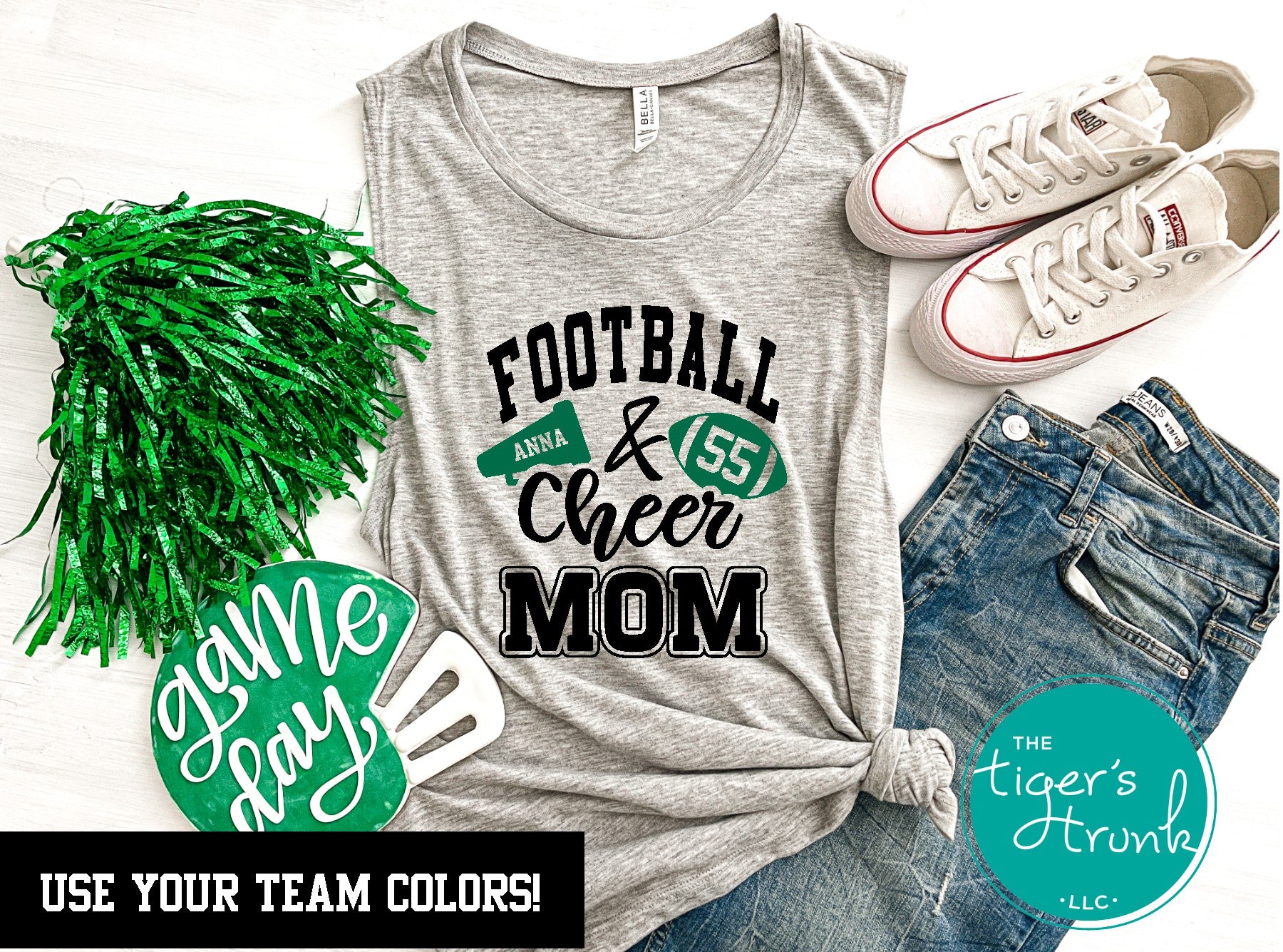 A gray muscle tank top with personalized text and graphics related to football and cheerleading, displayed alongside green pom poms and sneakers.